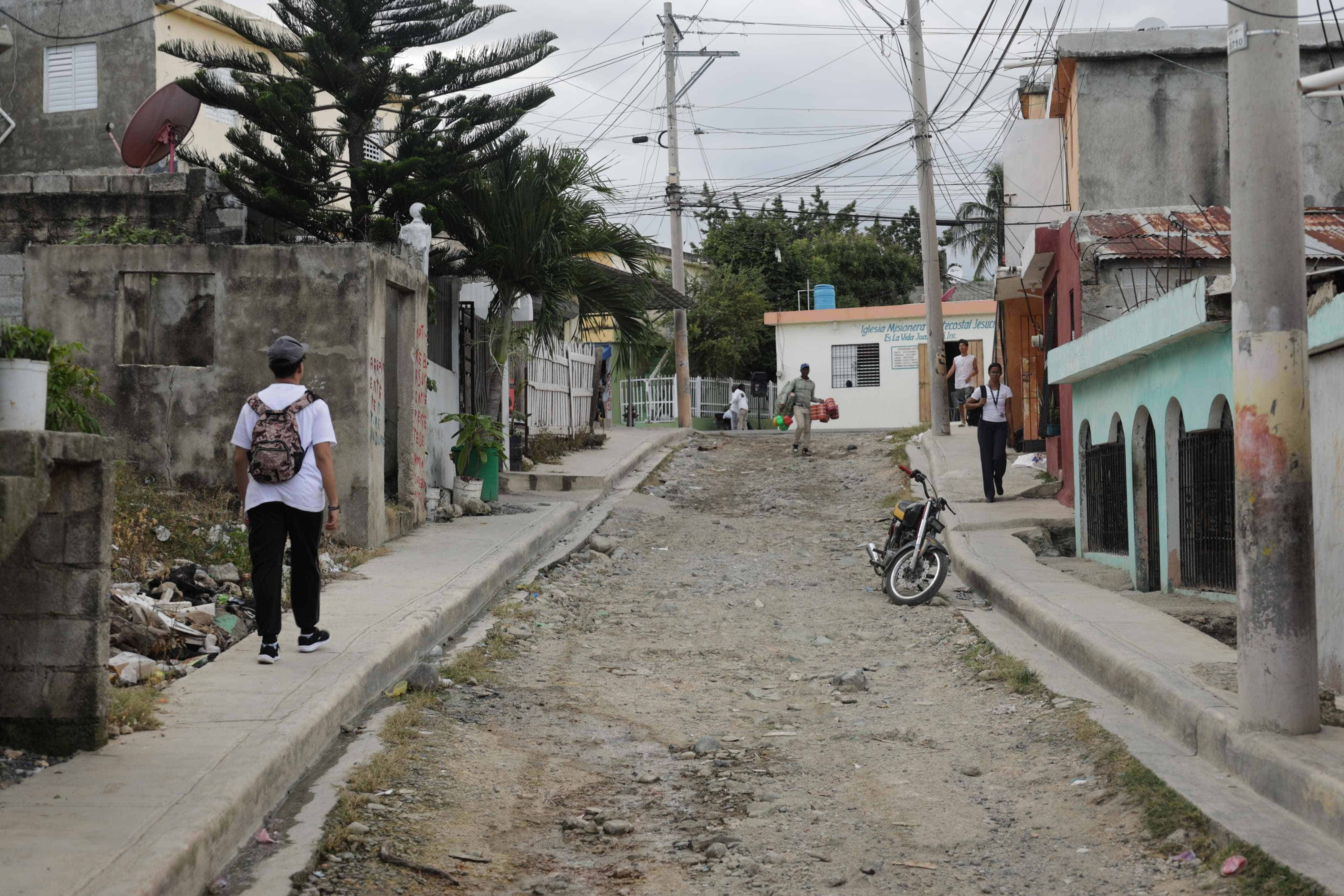 Panorama de la calle donde está ubicada la casa que los vecinos del Gran Poder de Dios en Los Alcarrizos señalan como residencia de la familia de Josué Medina Vásquez.