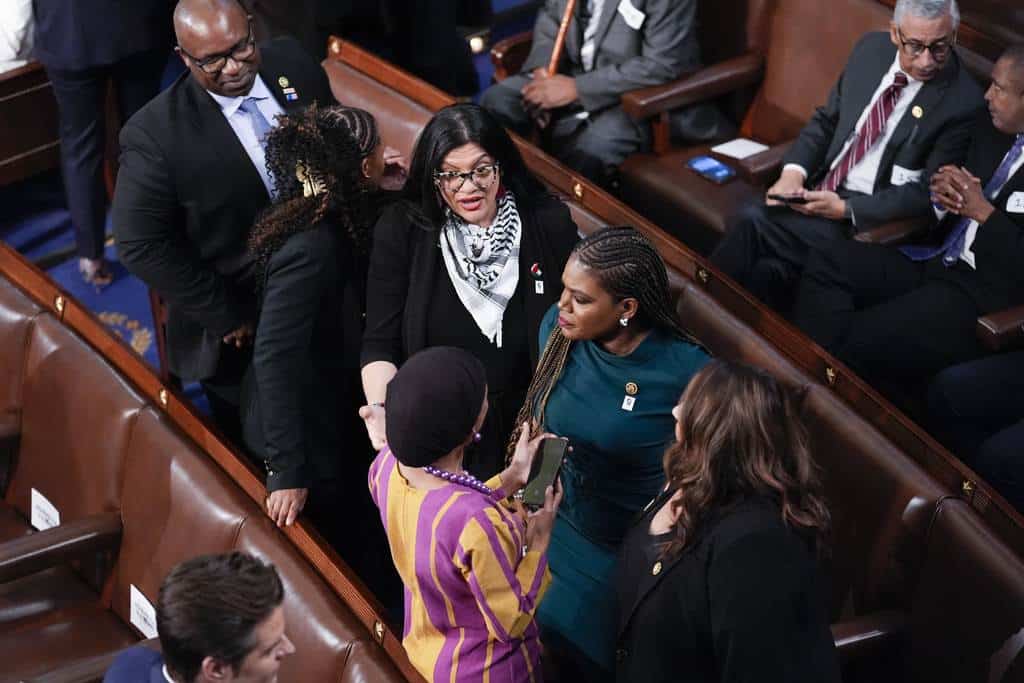 Mujeres miembros del Congreso, incluida la representante Rashida Tlaib, demócrata de Michigan, arriba, la representante Cori Bush, demócrata de Missouri, en el centro, y el representante Iihan Omar, demócrata de Minnesota, abajo a la izquierda, hablan antes de que el presidente Joe Biden llegue para pronunciar su discurso sobre el Estado de la Unión en una sesión conjunta del Congreso, en el Capitolio en Washington, el jueves 7 de marzo de 2024.