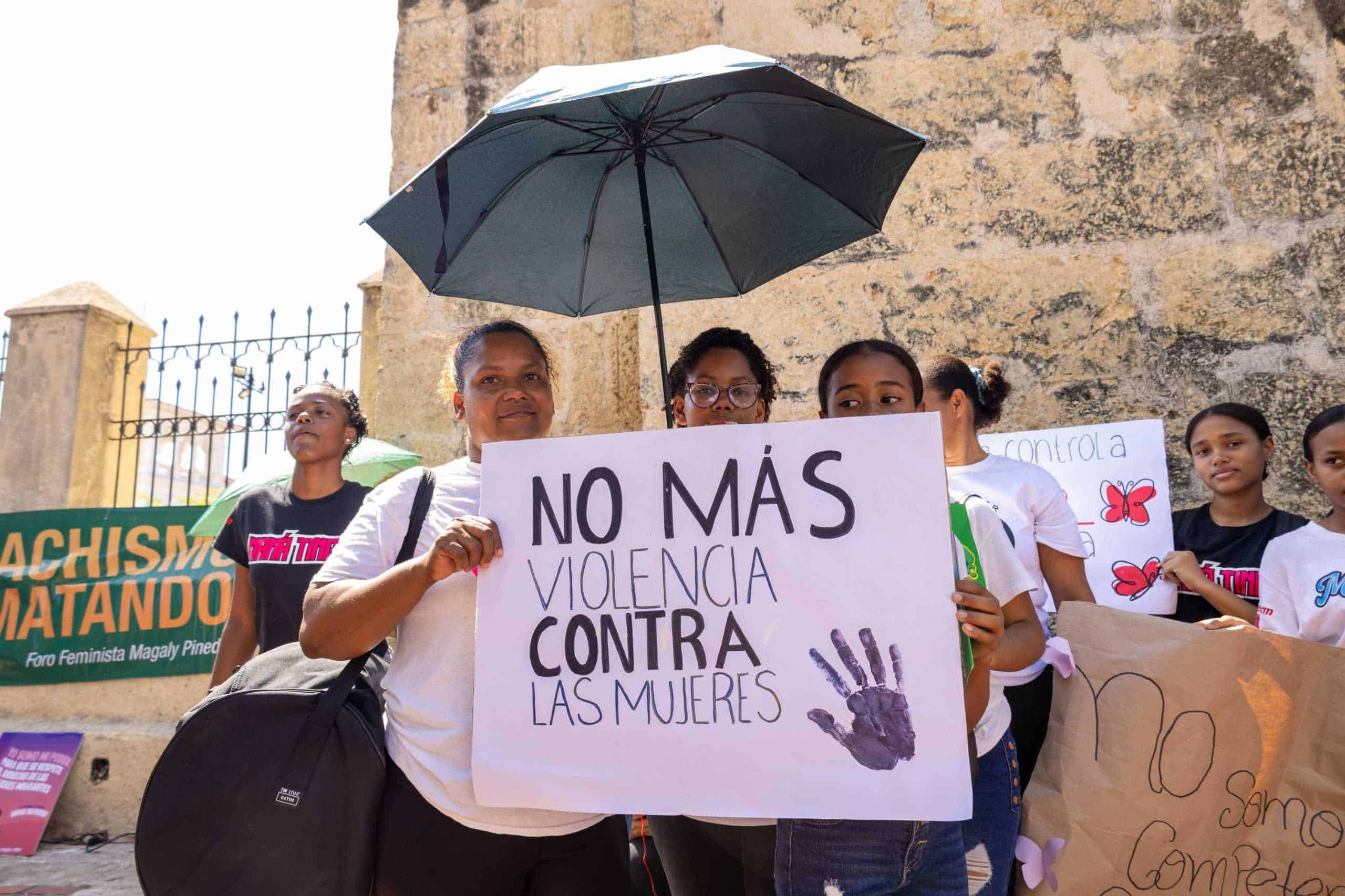 Asistentes a la movilización con pancartas donde se leen mensajes en contra de los feminicidios.