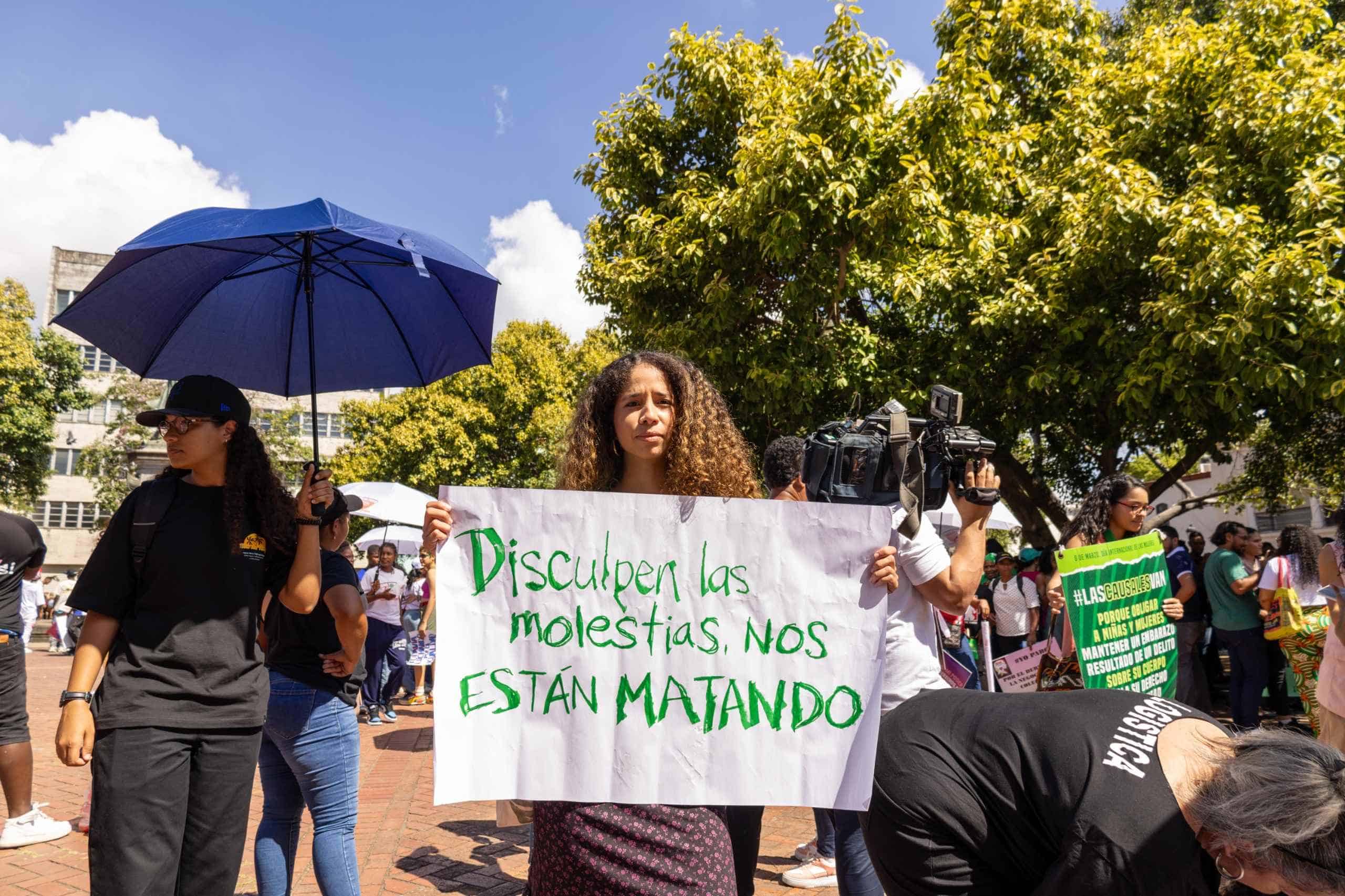 Asistentes a la movilización con pancartas donde se leen mensajes en contra de los feminicidios.