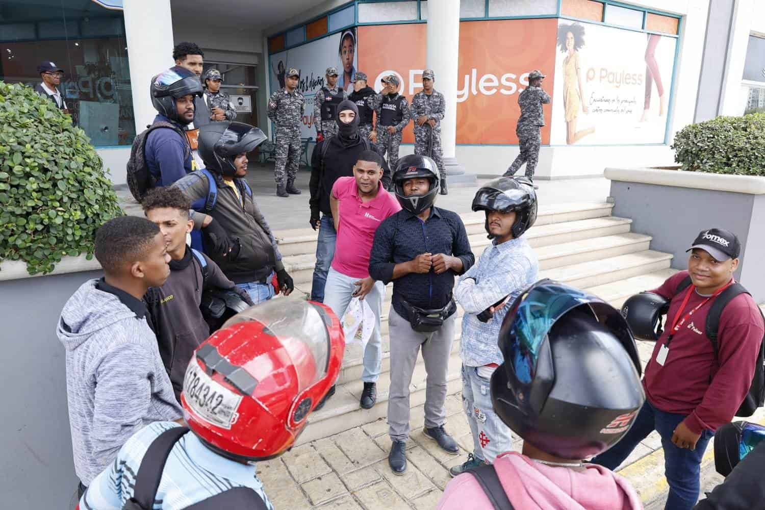 Un grupo de moto Uber a las afueras de Diamond Mall, mientras son custodiados por agentes policiales.