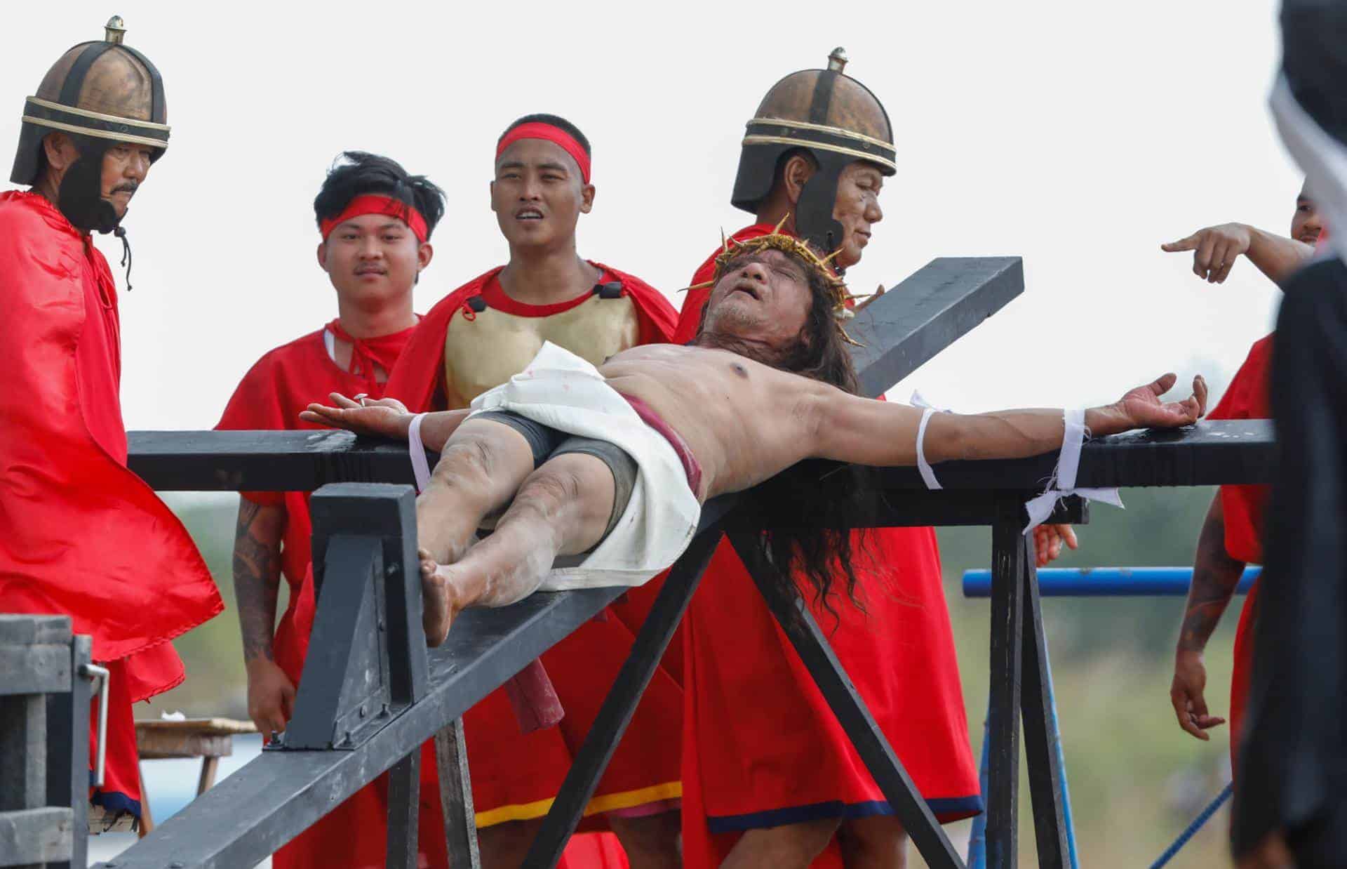 El filipino Rubén Enaje (C), que representa a Jesucristo, es clavado en una cruz de madera durante una recreación de la crucifixión de Jesucristo con motivo del Viernes Santo en San Fernando Ciudad, provincia de Pampanga, Filipinas, 29 de marzo de 2024.