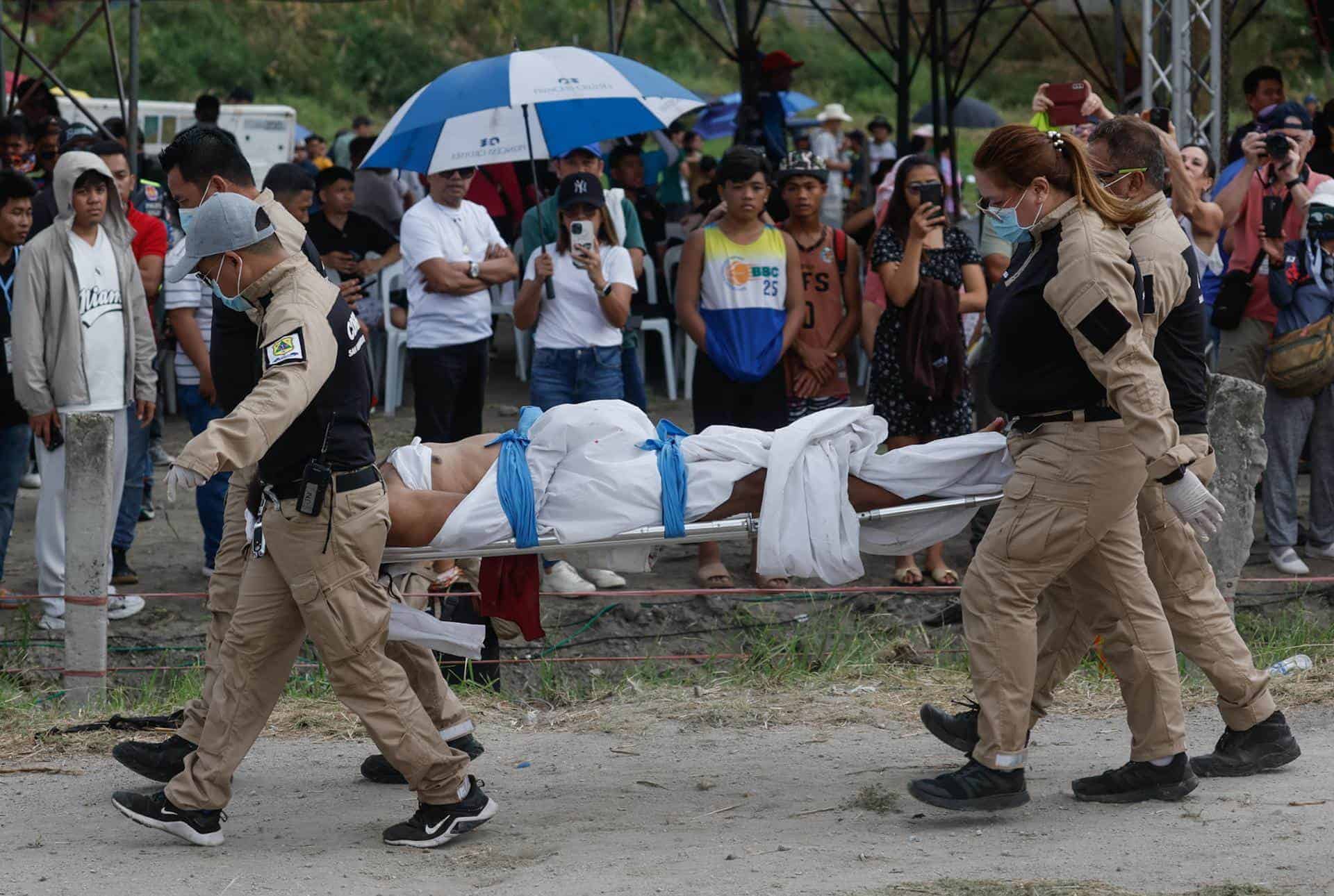 El filipino Rubén Enaje, que interpreta a Jesucristo, es llevado sobre una tabla espinal por miembros de un equipo de respuesta a emergencias tras una recreación de la crucifixión y muerte de Jesucristo para conmemorar el Viernes Santo en la ciudad de San Fernando, provincia de Pampanga, Filipinas, 29 de marzo de 2024.