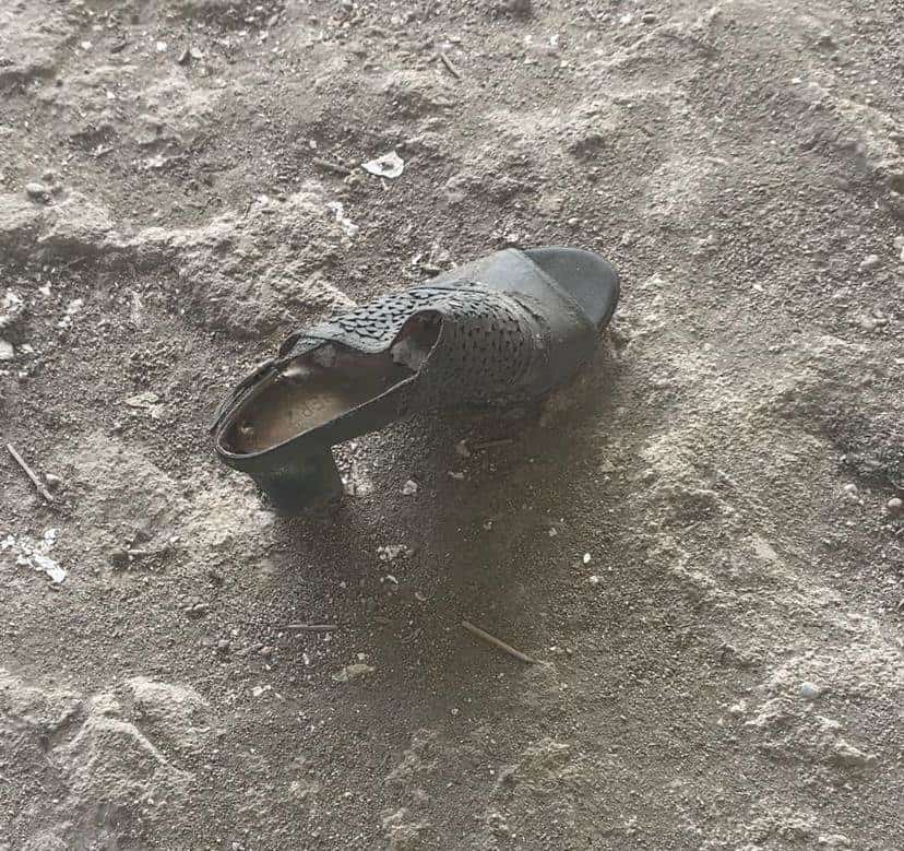 Un zapato con tacón, desgastado y sucio.