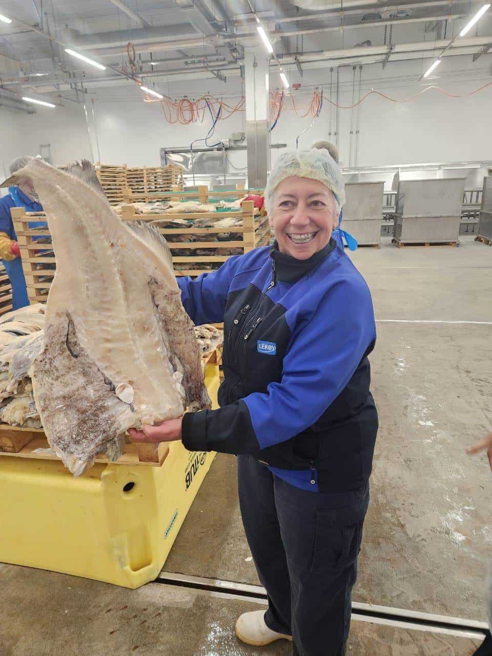 La Salted Fish Department Manager, Teresa Miranda, sujetando uno de los bacalos abiertos antes del proceso de secado en las instalaciones de Leroy