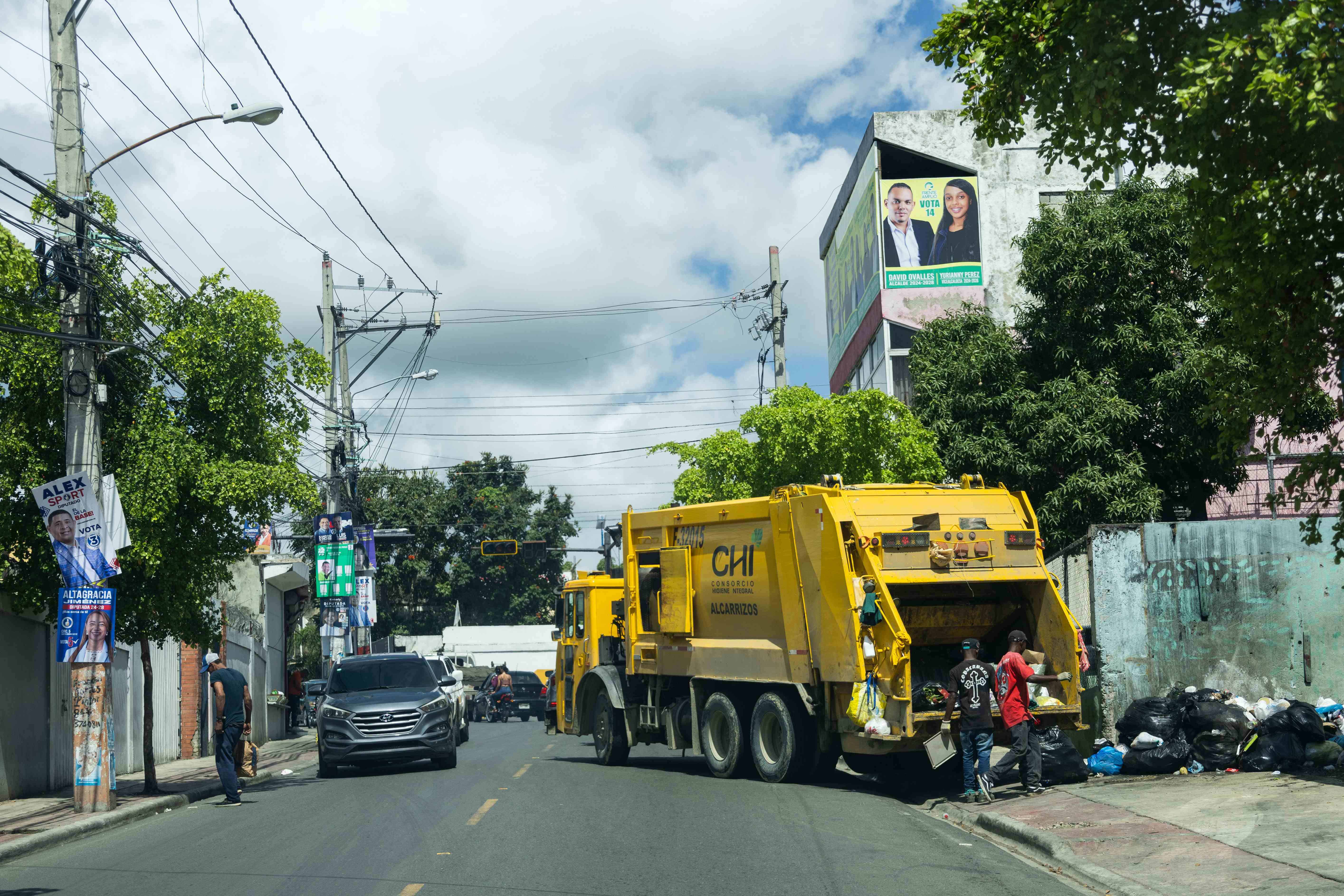 Camiones recolectores de residuos recorren calles de Los Alcarrizos.