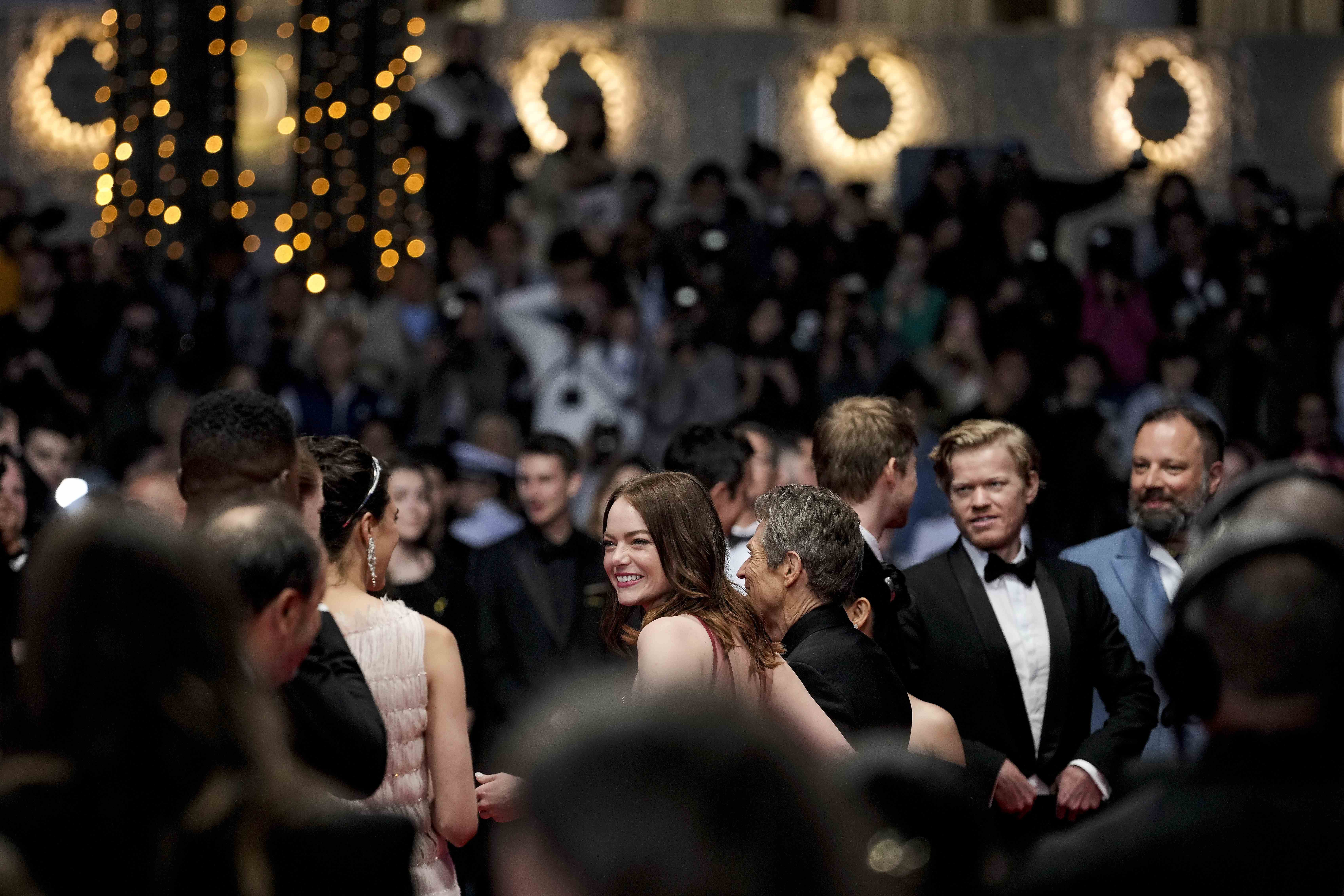 Emma Stone, centro, posa para retratos al salir de la premiere de 'Kinds of Kindness' en la en 77a edición del Festival de Cine de Cannes en Francia.