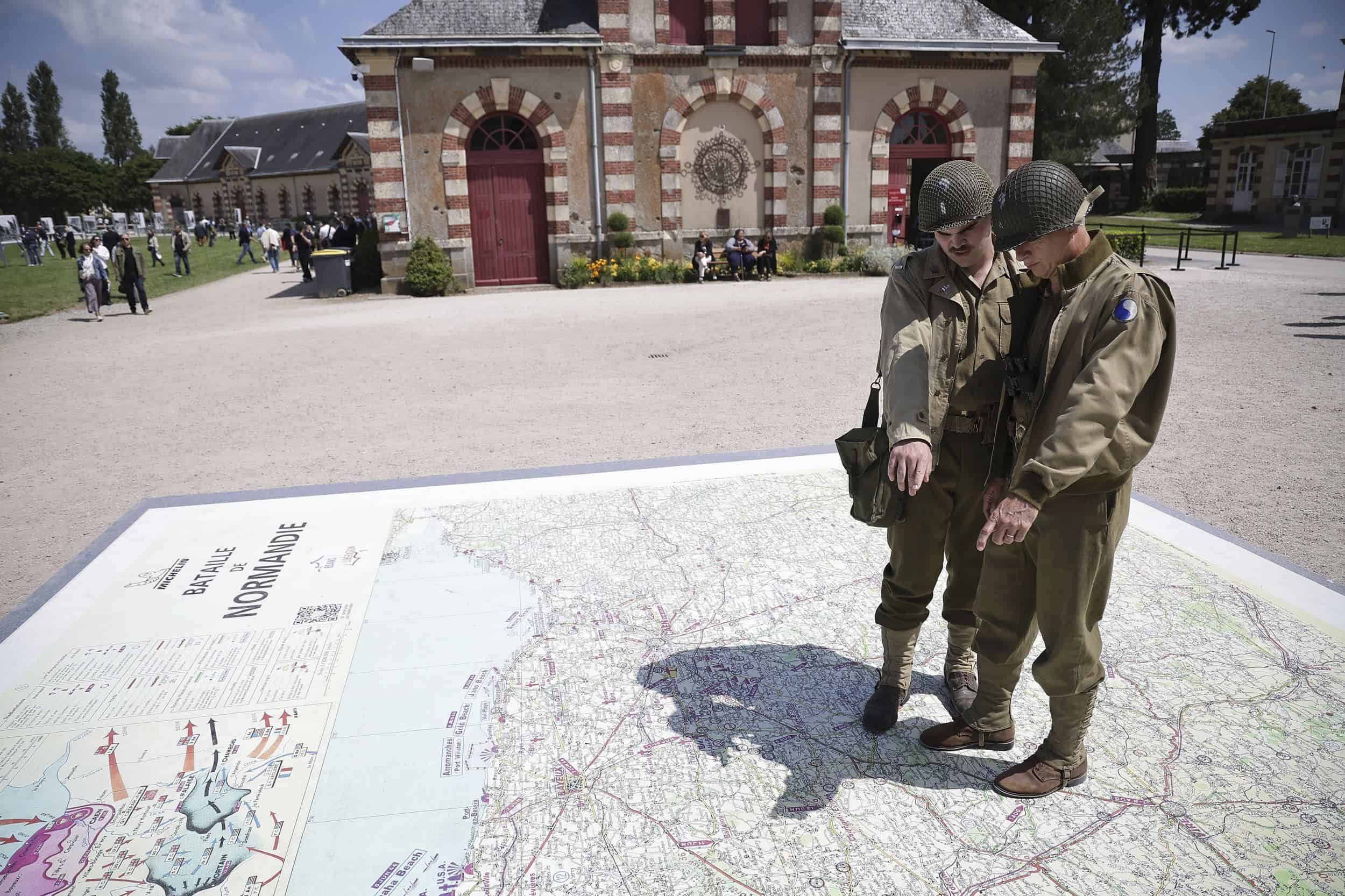 Los entusiastas de la Segunda Guerra Mundial miran el mapa del desembarco del Día D, antes de las celebraciones del 80 aniversario del desembarco del Día D en Normandía, en Saint-Lo, Normandía, el miércoles 5 de junio de 2024.