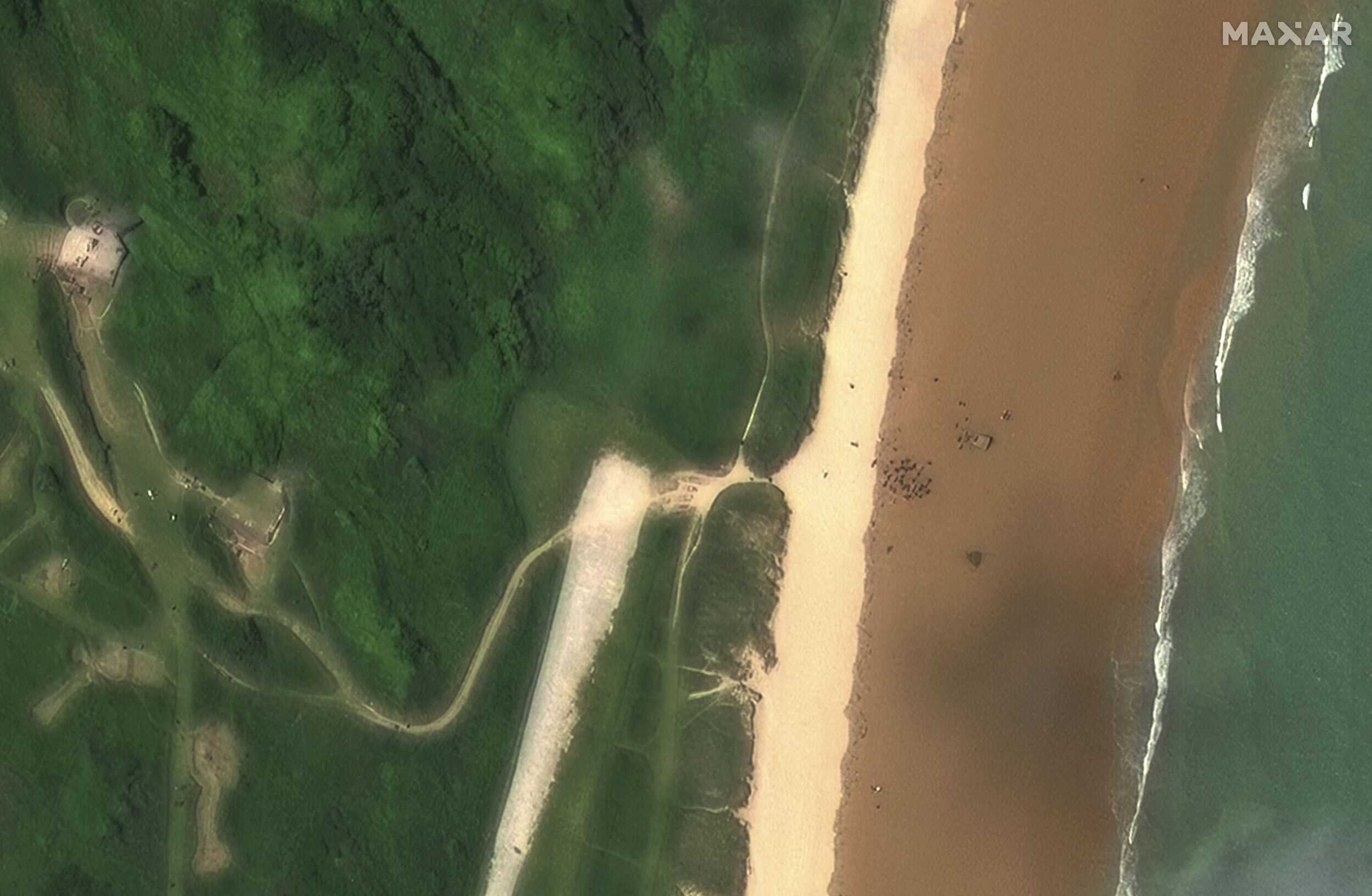 Esta imagen satelital publicada por Maxar Technologies muestra a personas reunidas en la playa de Omaha, una de las cinco áreas de desembarco en la playa del asalto anfibio durante la Segunda Guerra Mundial, para el 80 aniversario del Día D.