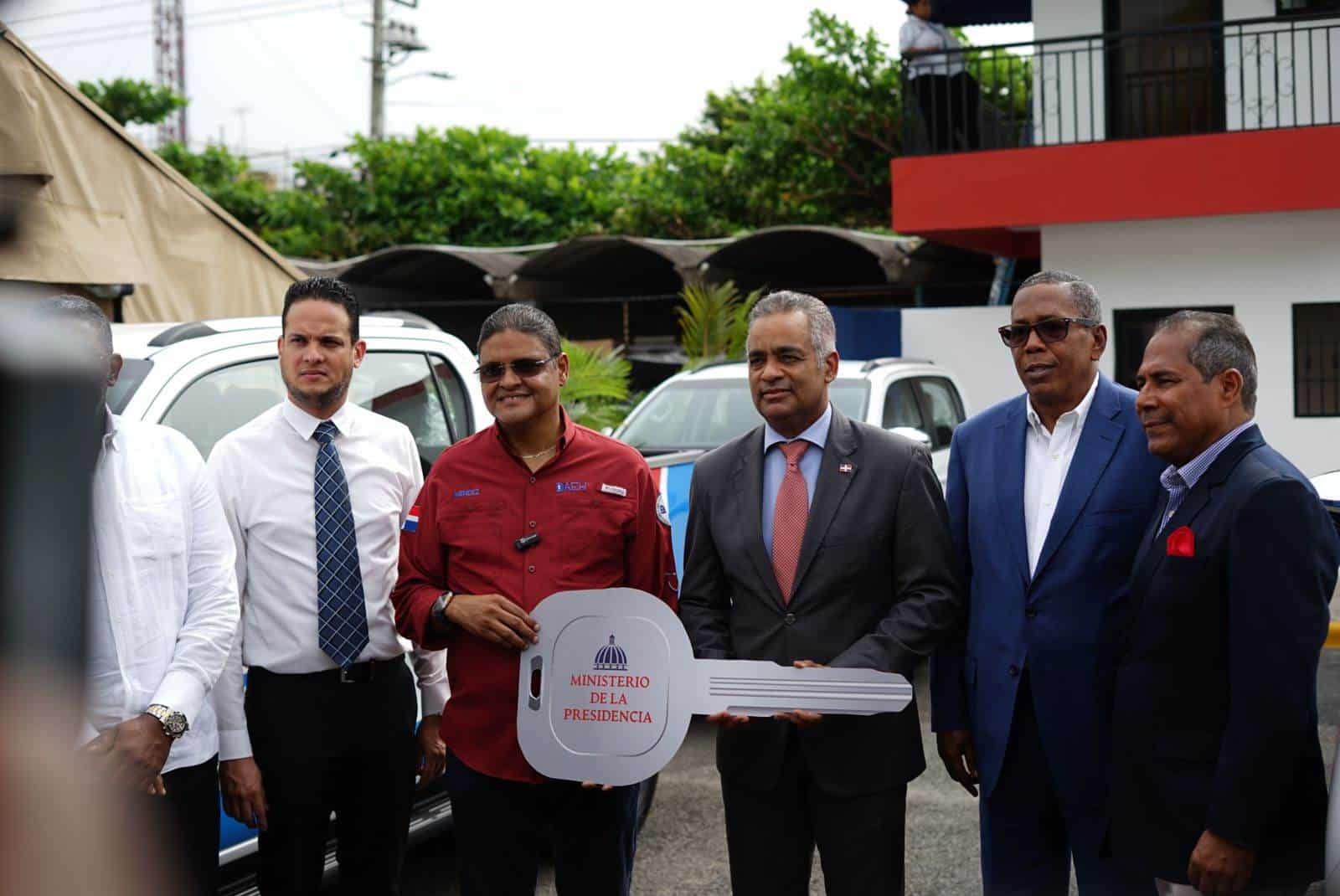 El director de la DAEH, Juan Manuel Méndez, recibe del ministro Joel Santos la llave simbólica en la entrega de las camionetas. 