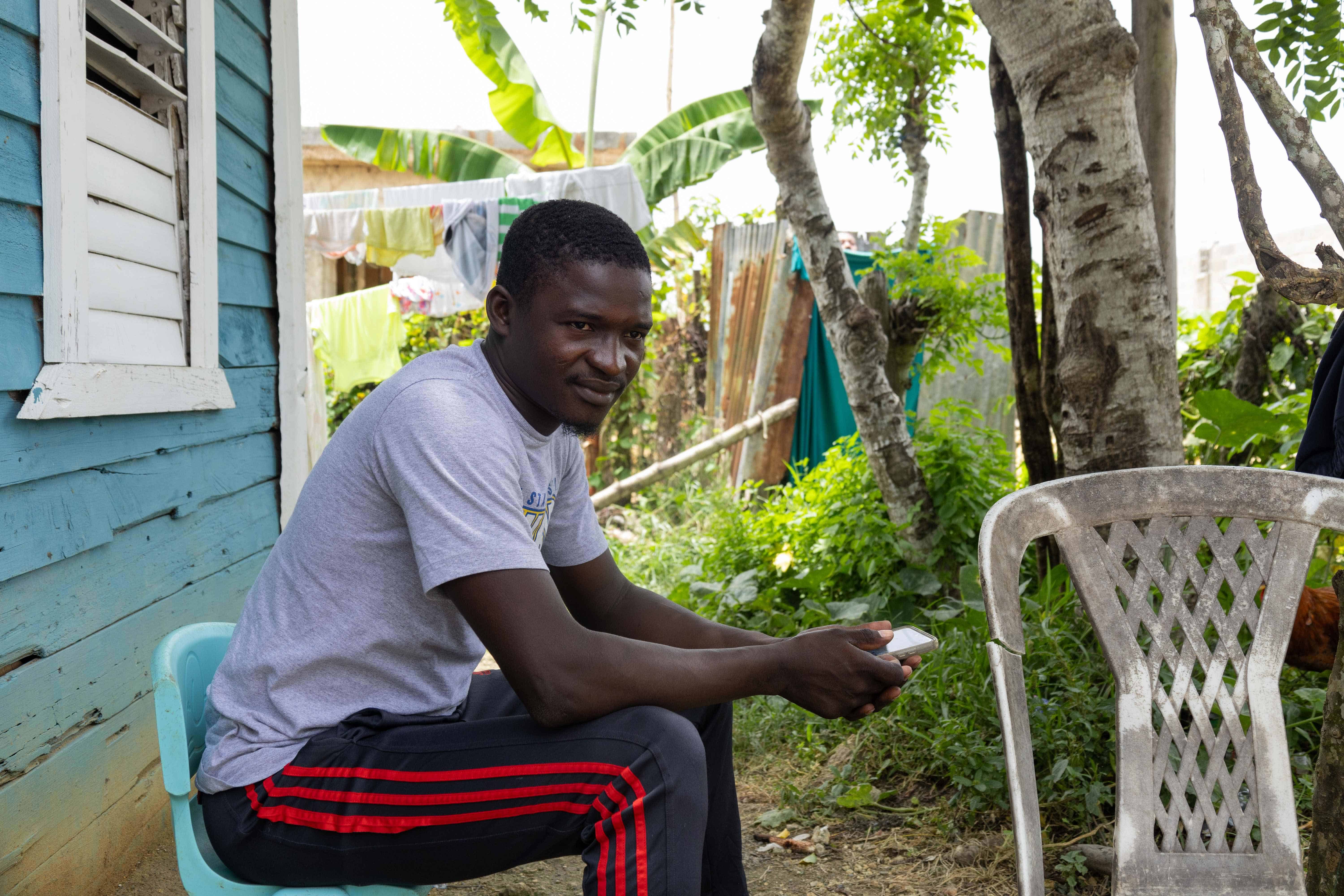 Mackenson, trabajador de la Zona Franca Riosur, sentado en una silla de plástico.