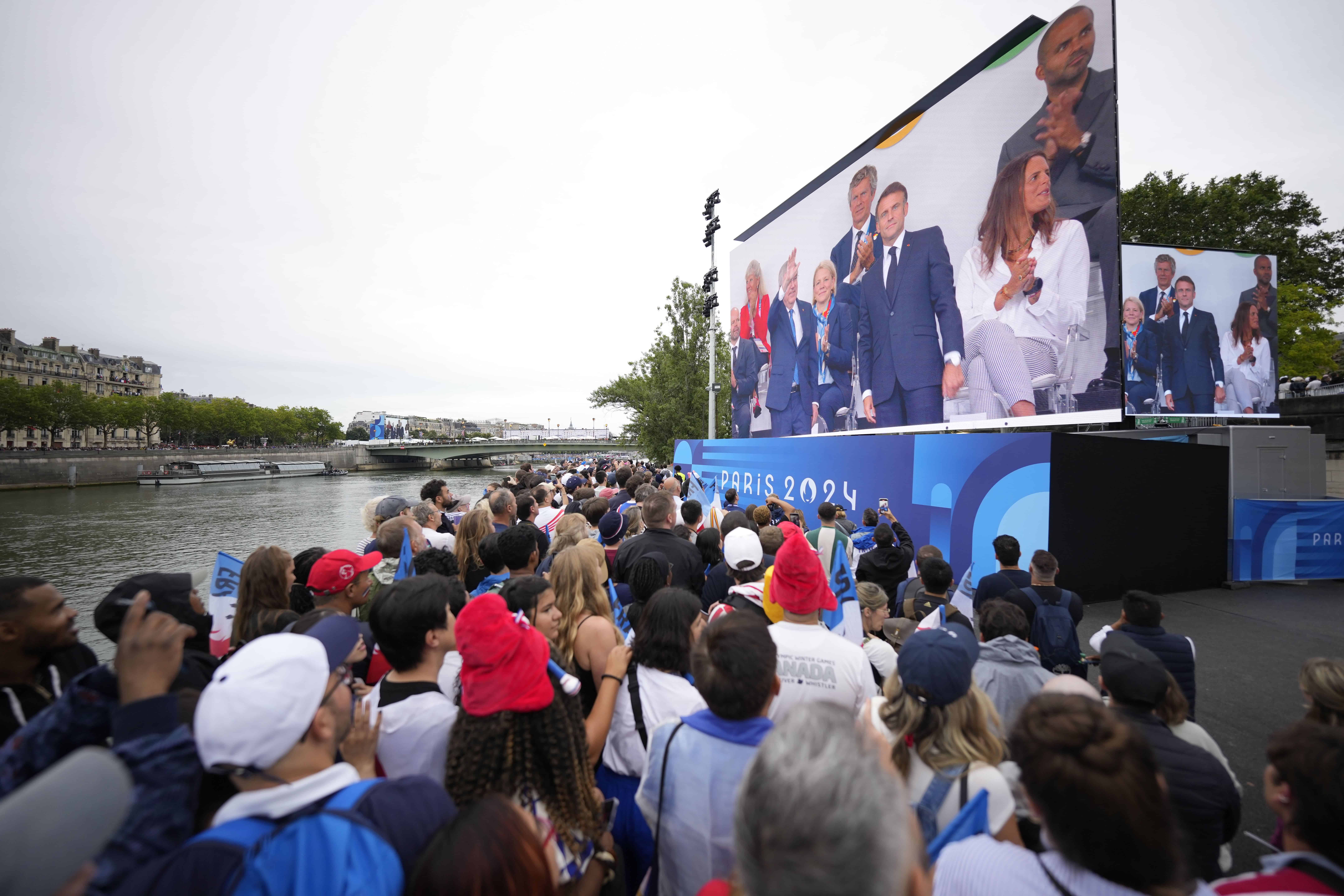 La gente observa en una pantalla gigante en París, Francia, la ceremonia de apertura de los Juegos Olímpicos de Verano de 2024, el viernes 26 de julio de 2024.