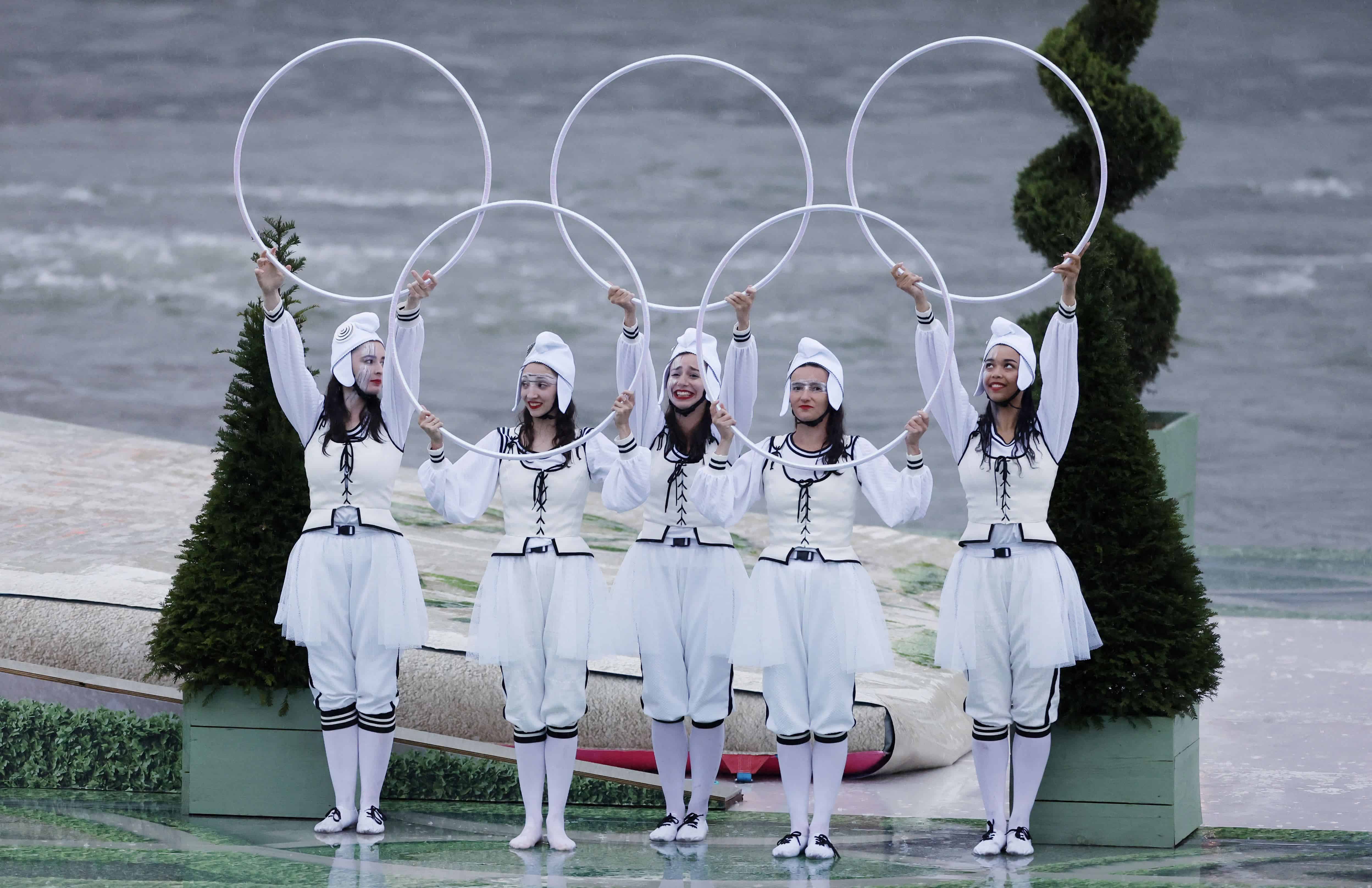 Los artistas sostienen aros con la forma de los anillos olímpicos en una plataforma flotante a lo largo del río Sena durante la ceremonia de apertura de los Juegos Olímpicos de Verano de 2024 en París, Francia, el viernes 26 de julio de 2024.