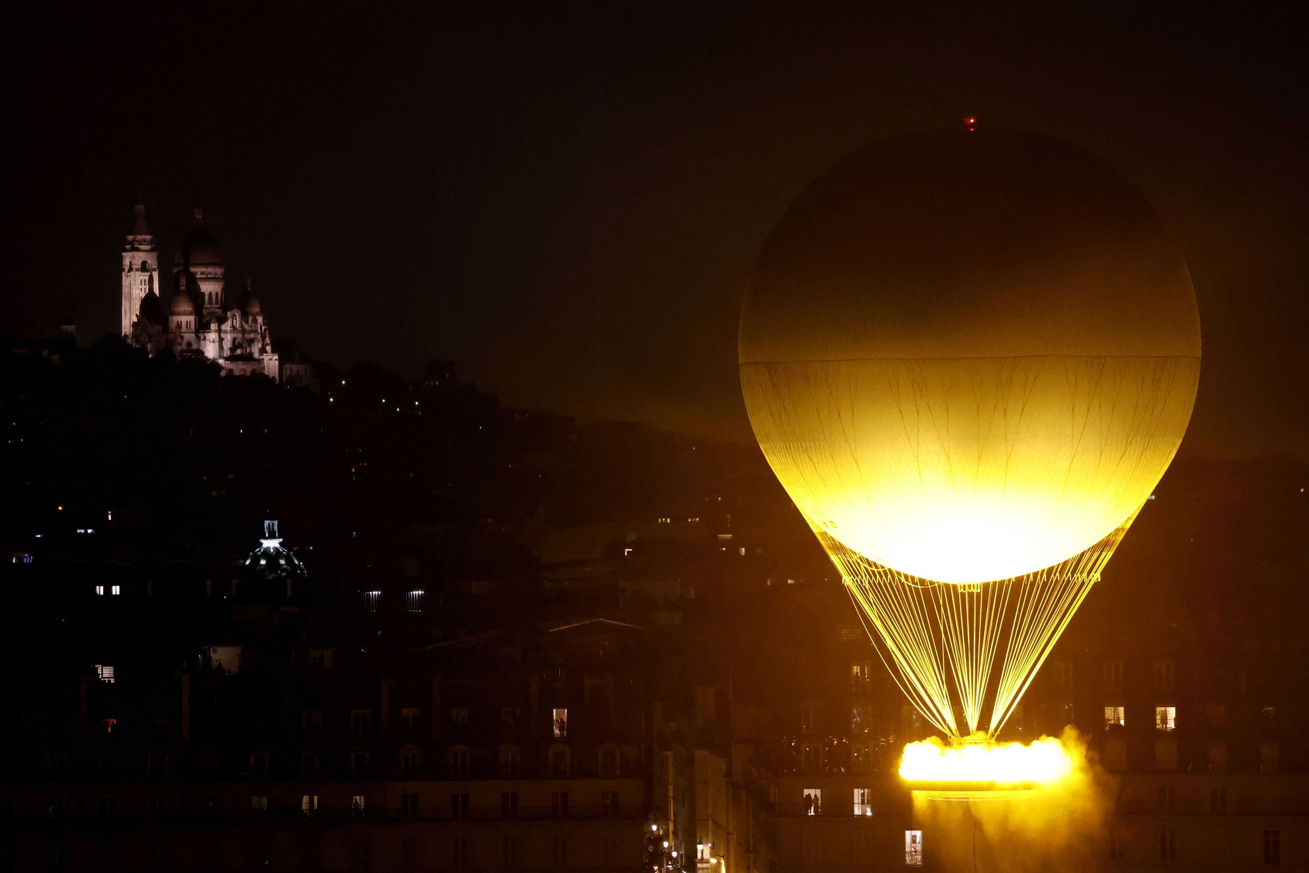 El pebetero, con la llama olímpica encendida, despega mientras está sujeto a un globo, en París, Francia, durante la ceremonia de apertura de los Juegos Olímpicos de Verano de 2024, el viernes 26 de julio de 2024.