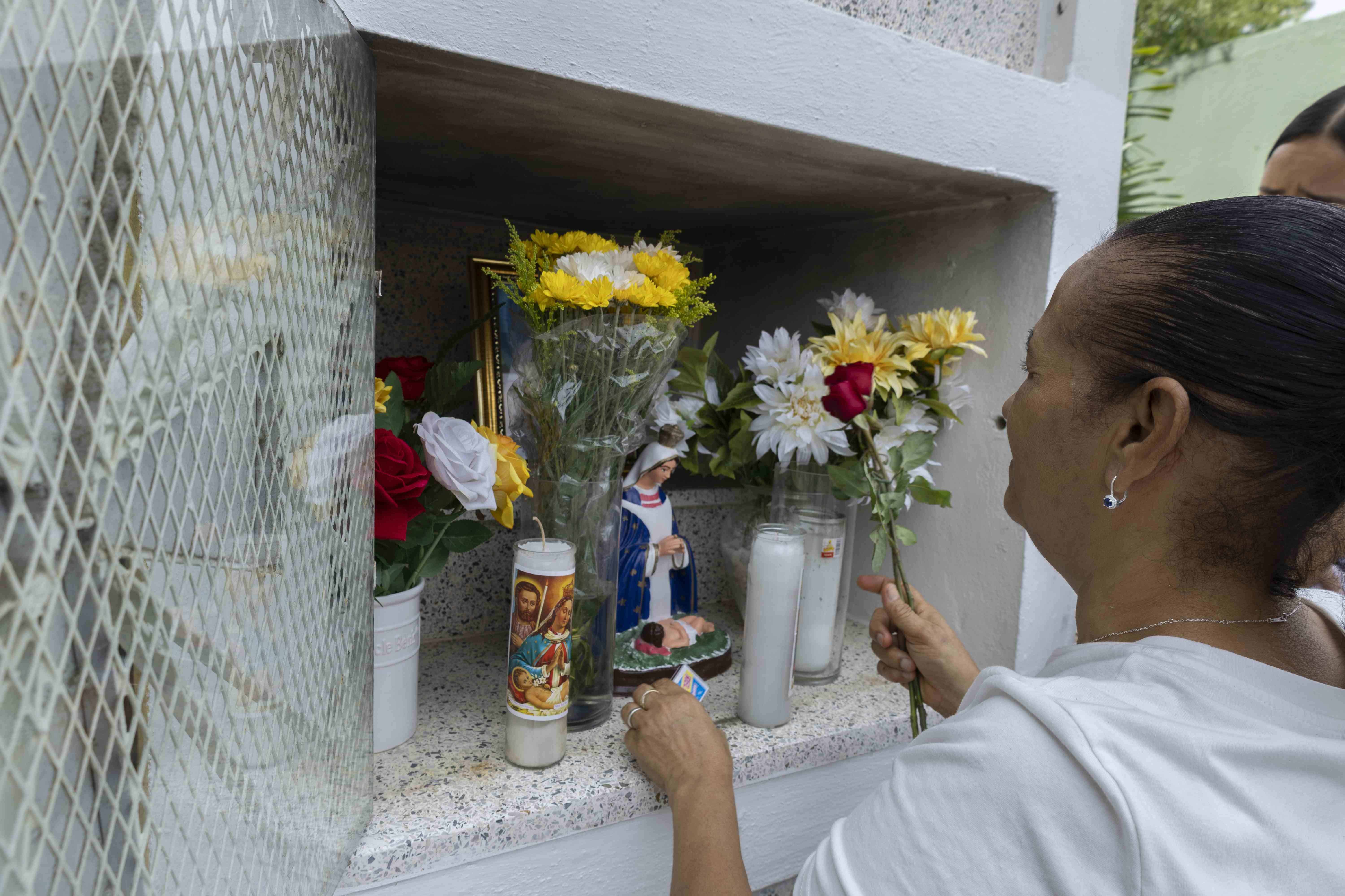 La esposa de José del Carmen Fernández le deja flores en su tumba.