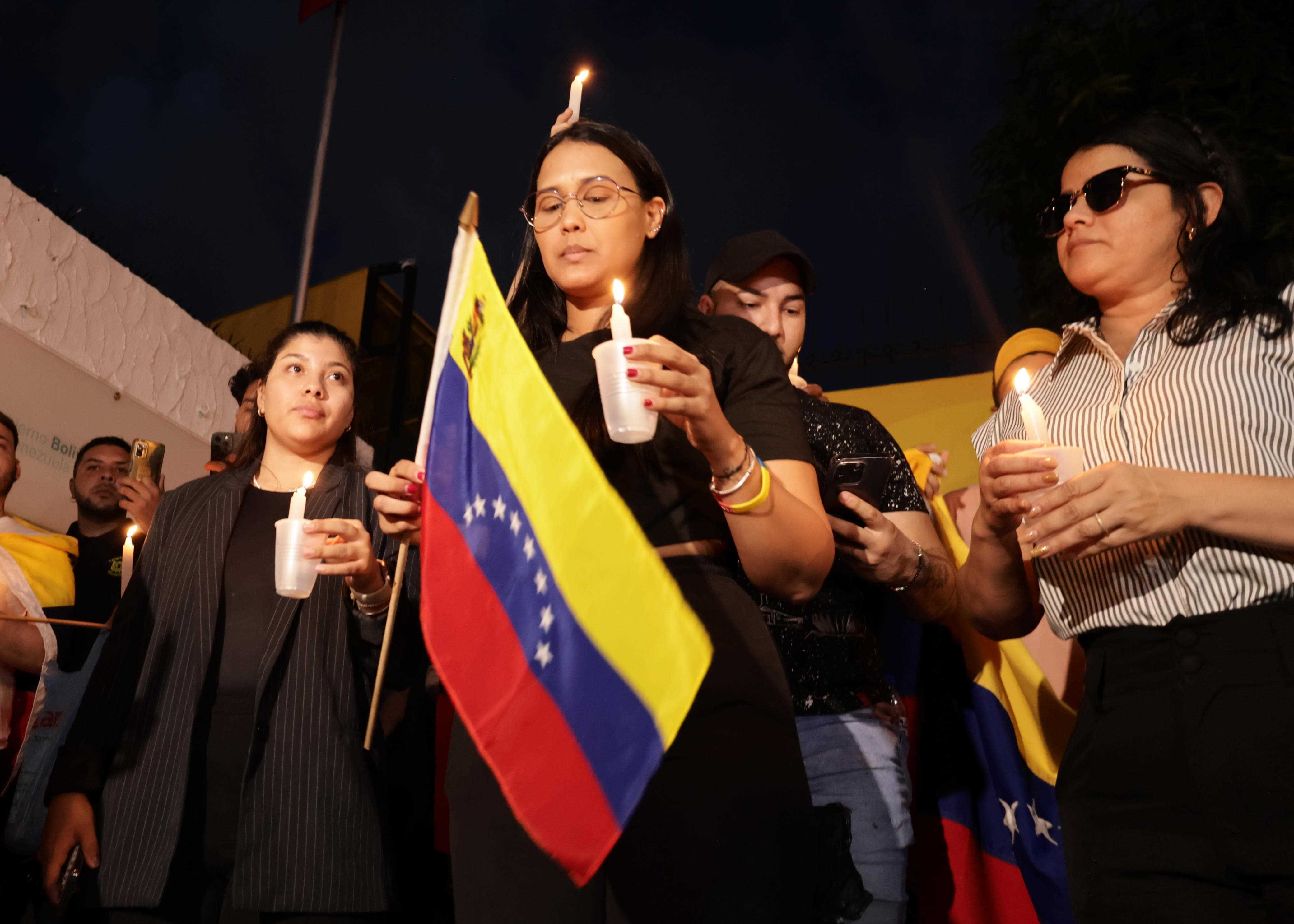 Venezolanos residentes en Santo Domingo se manifiestan en contra de los resultados de las elecciones con velas encendidas.