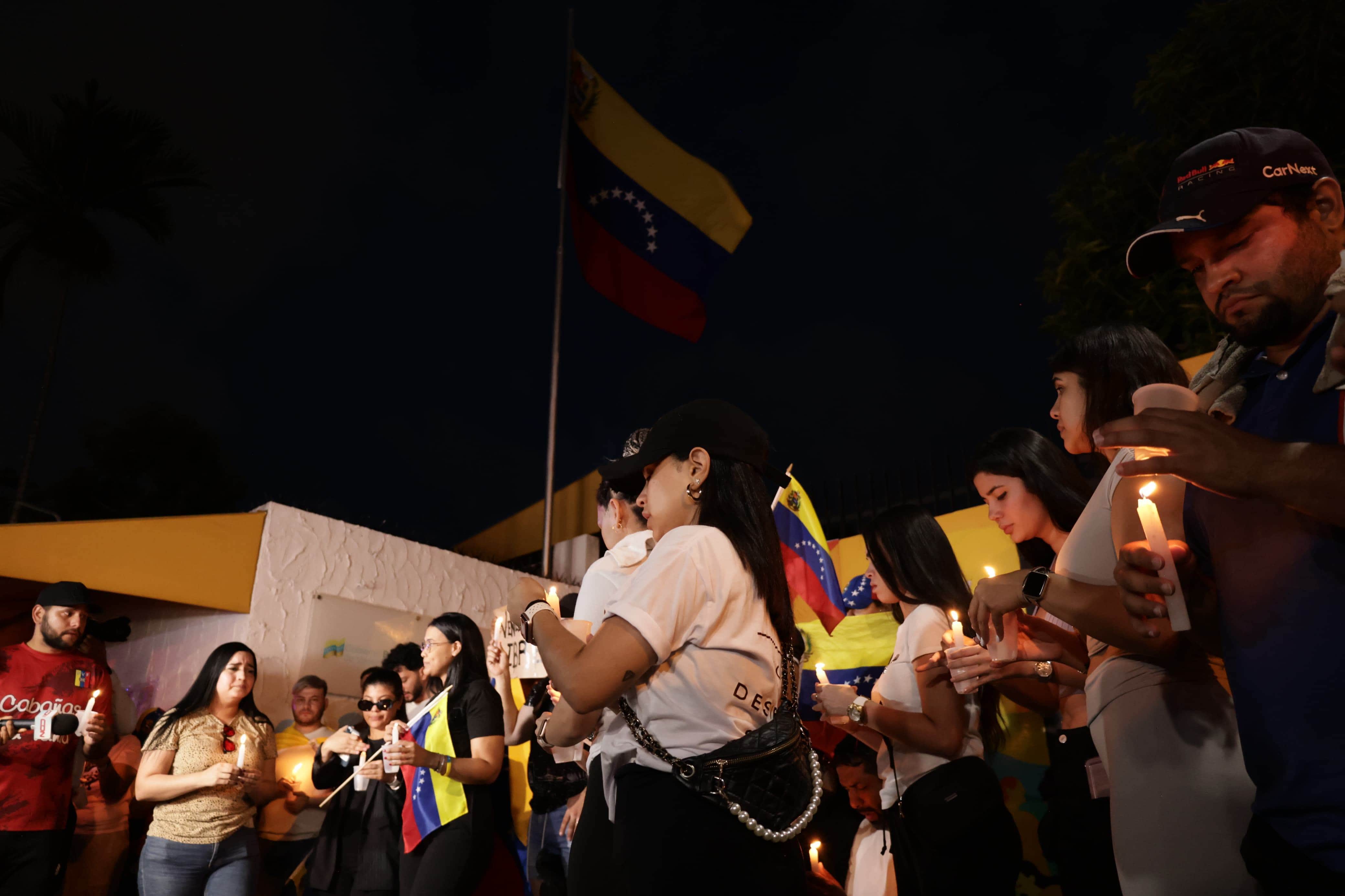 Con velas encendidas, venezolanos piden frente al consulado de su país, libertad.