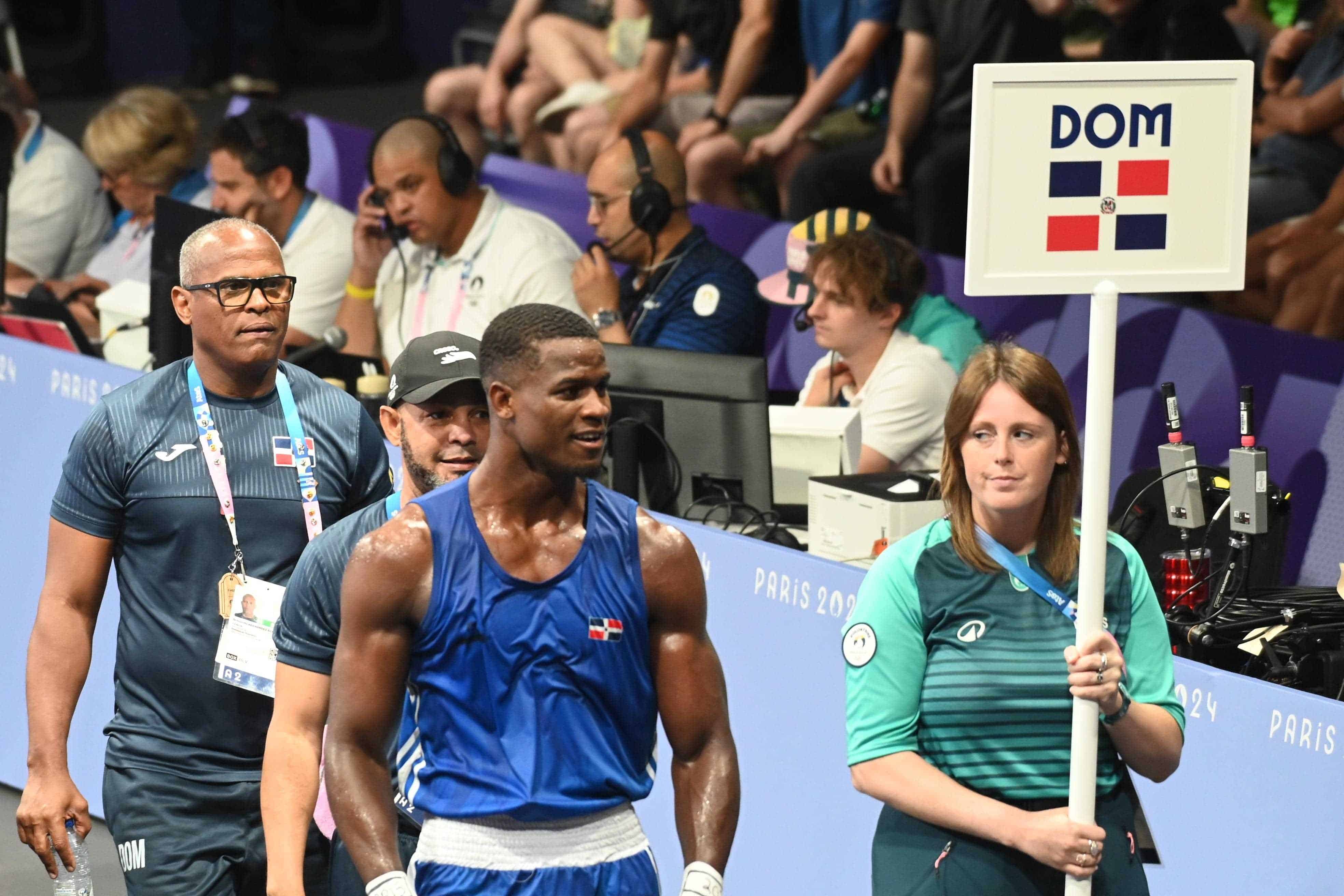 Cristian Pinales avanza a los camerinos después de su combate ante Tanglatihan Tuohetaerbieke  (China), en los 8vos. de final. Lo acompaña su entrenador Armando Hernández, primero desde la izquierda este martes 30 de julio de 2024.