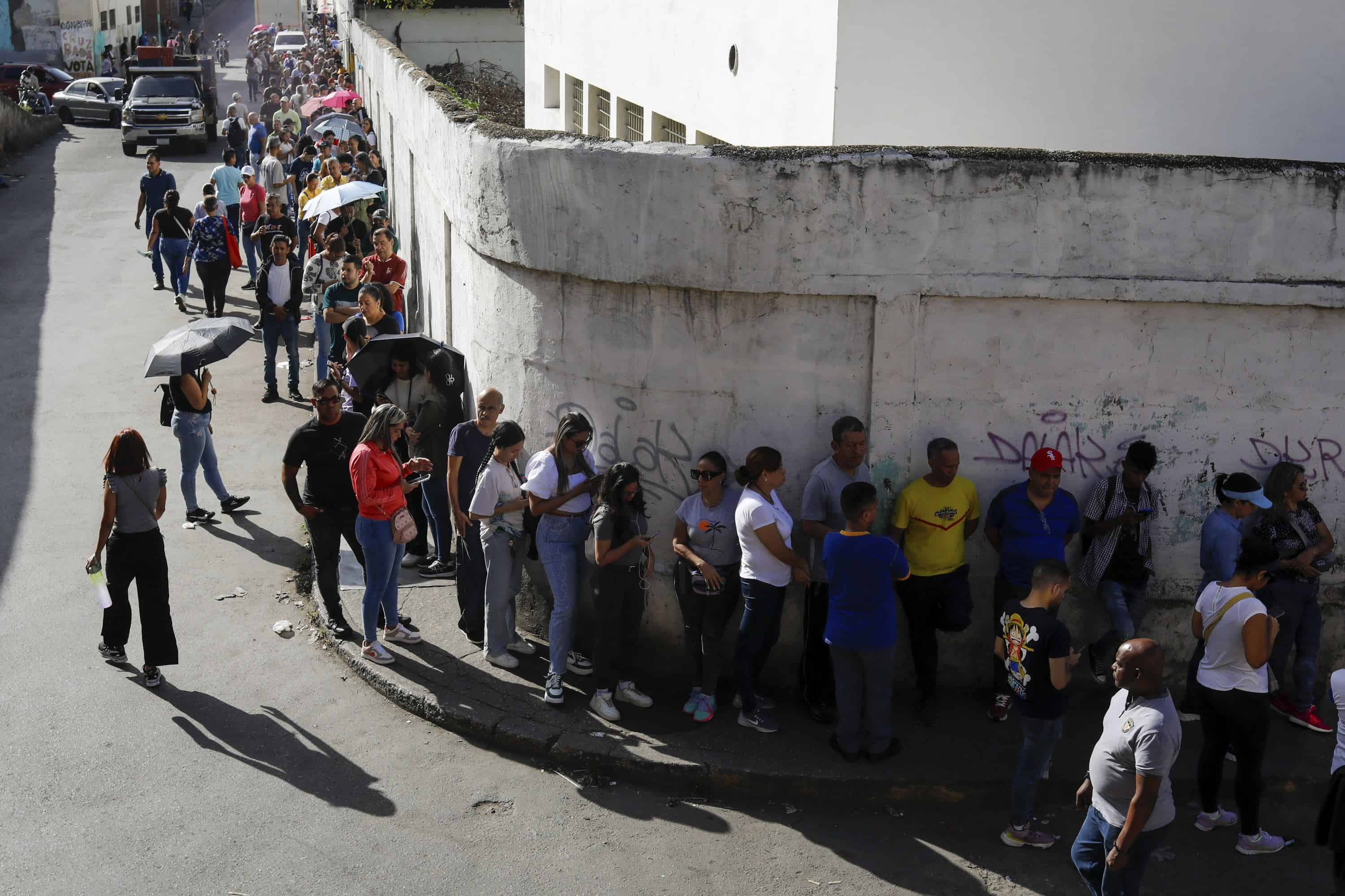 Venezolanos hacen fila afuera de un centro de votación durante la elección presidencial en Caracas, Venezuela, el domingo 28 de julio de 2024.