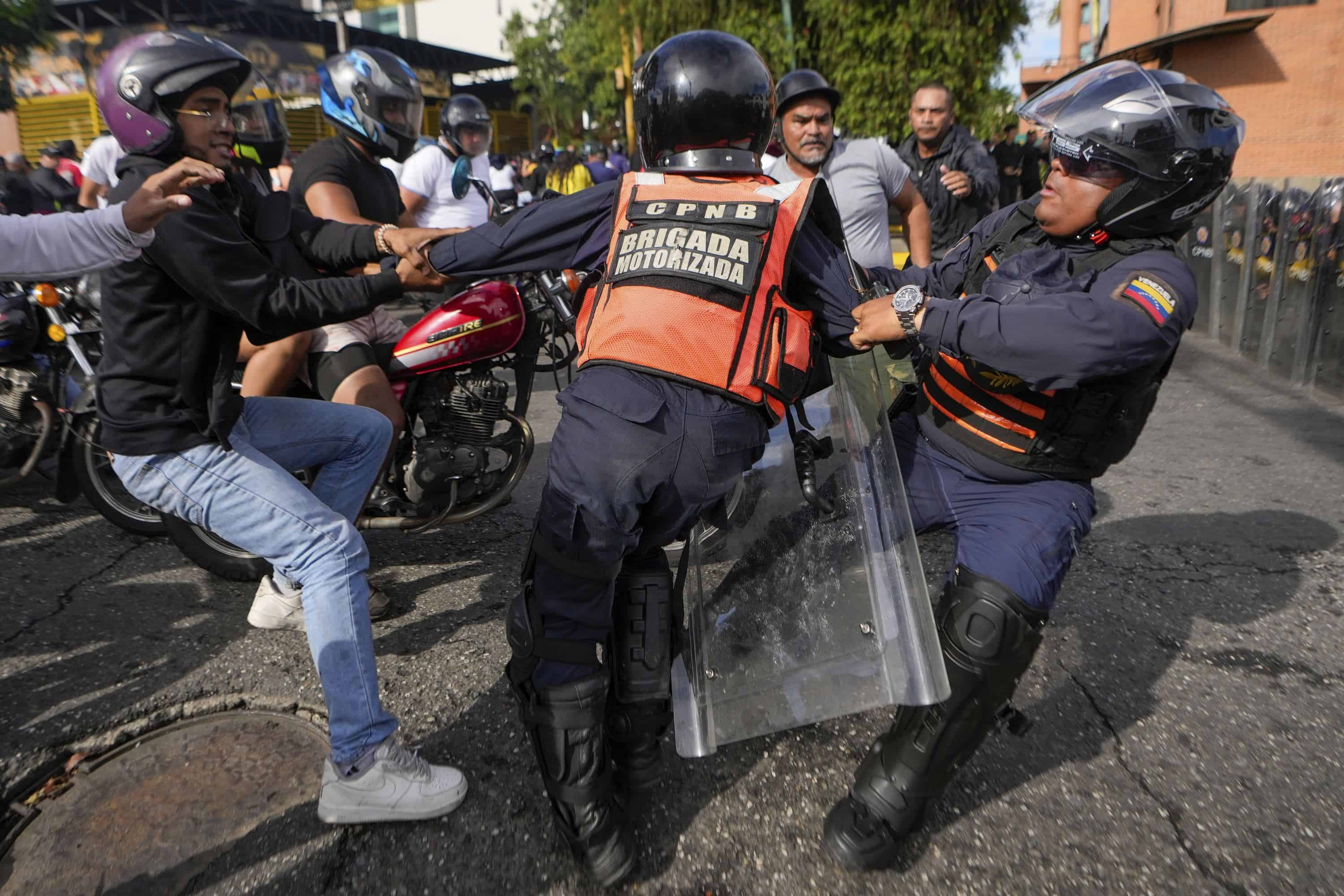 Un manifestante se pelea con la policía durante manifestaciones contra los resultados oficiales de las elecciones que declaran la reelección del presidente Nicolás Maduro, el día después de la votación en Caracas, Venezuela, el lunes 29 de julio de 2024.