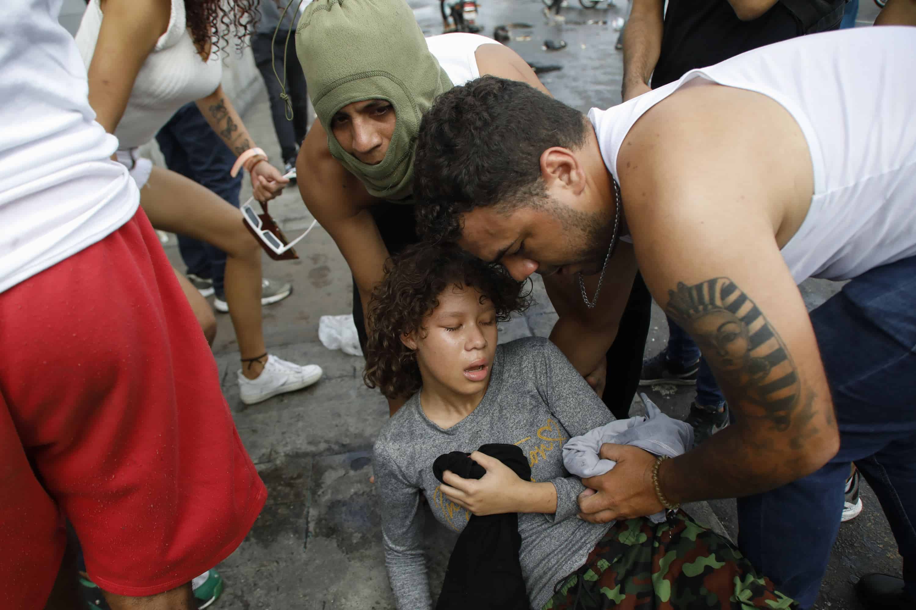 La gente cuida a un manifestante afectado por gases lacrimógenos lanzados por la policía durante las manifestaciones contra los resultados oficiales de las elecciones que declaran la reelección del presidente Nicolás Maduro, el día después de la votación, en el barrio Catia de Caracas, Venezuela, el lunes 29 de julio de 2024.