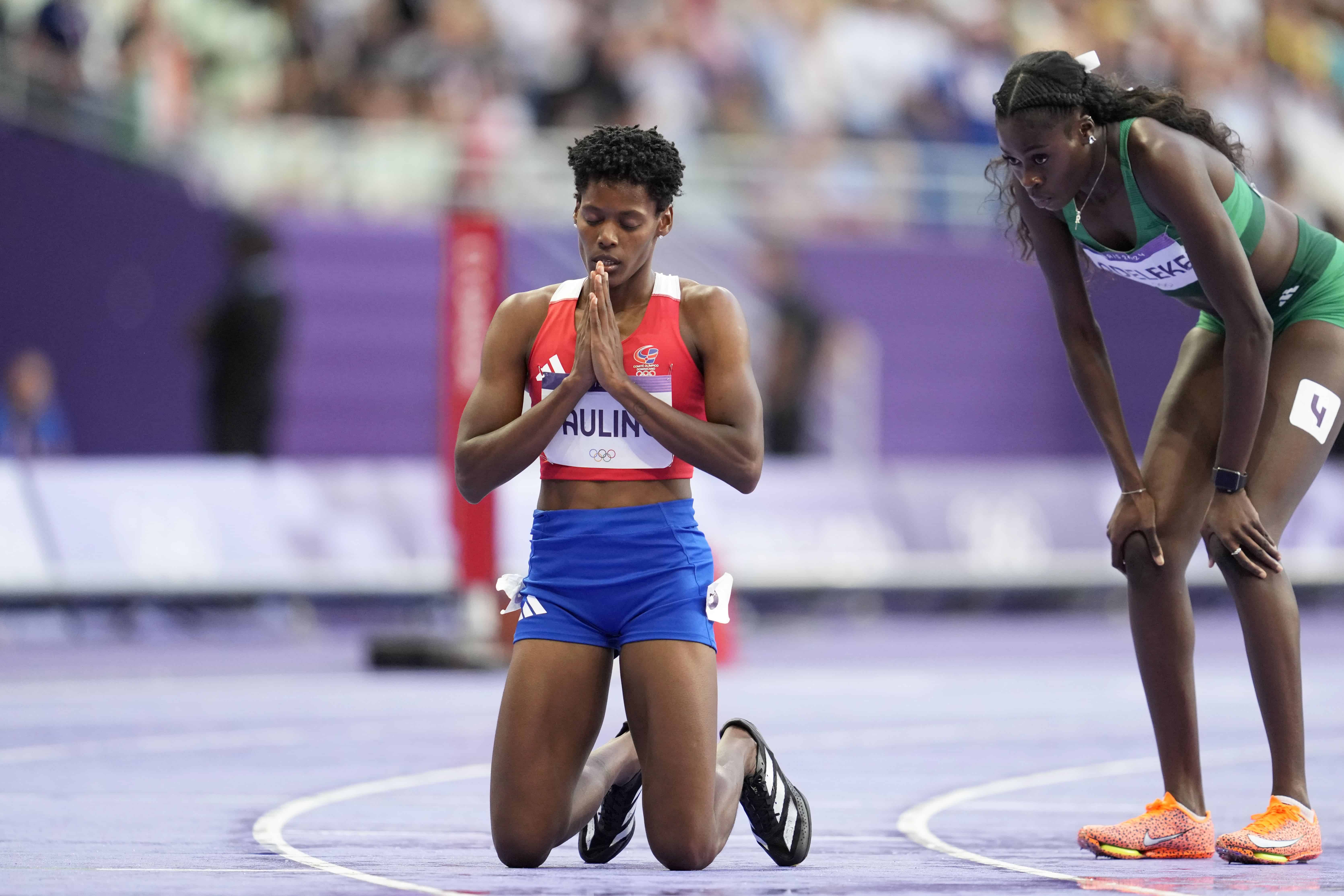 Marileidy Paulino se arrodilla en la pista después de ganar la medalla de oro en la final femenina de 400 metros en los Juegos Olímpicos de Verano de 2024, el viernes 9 de agosto de 2024, en Saint-Denis, Francia