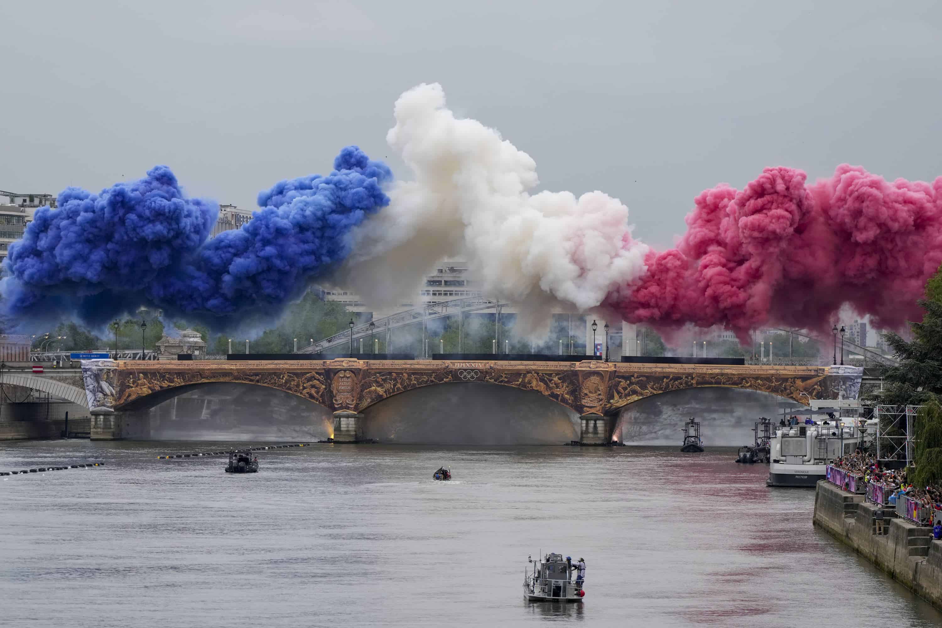 Humo ceremonial con los colores de la bandera de Francia aparece sobre el río Sena en París, Francia, durante la ceremonia de apertura de los Juegos Olímpicos de Verano de 2024, el viernes 26 de julio de 2024.