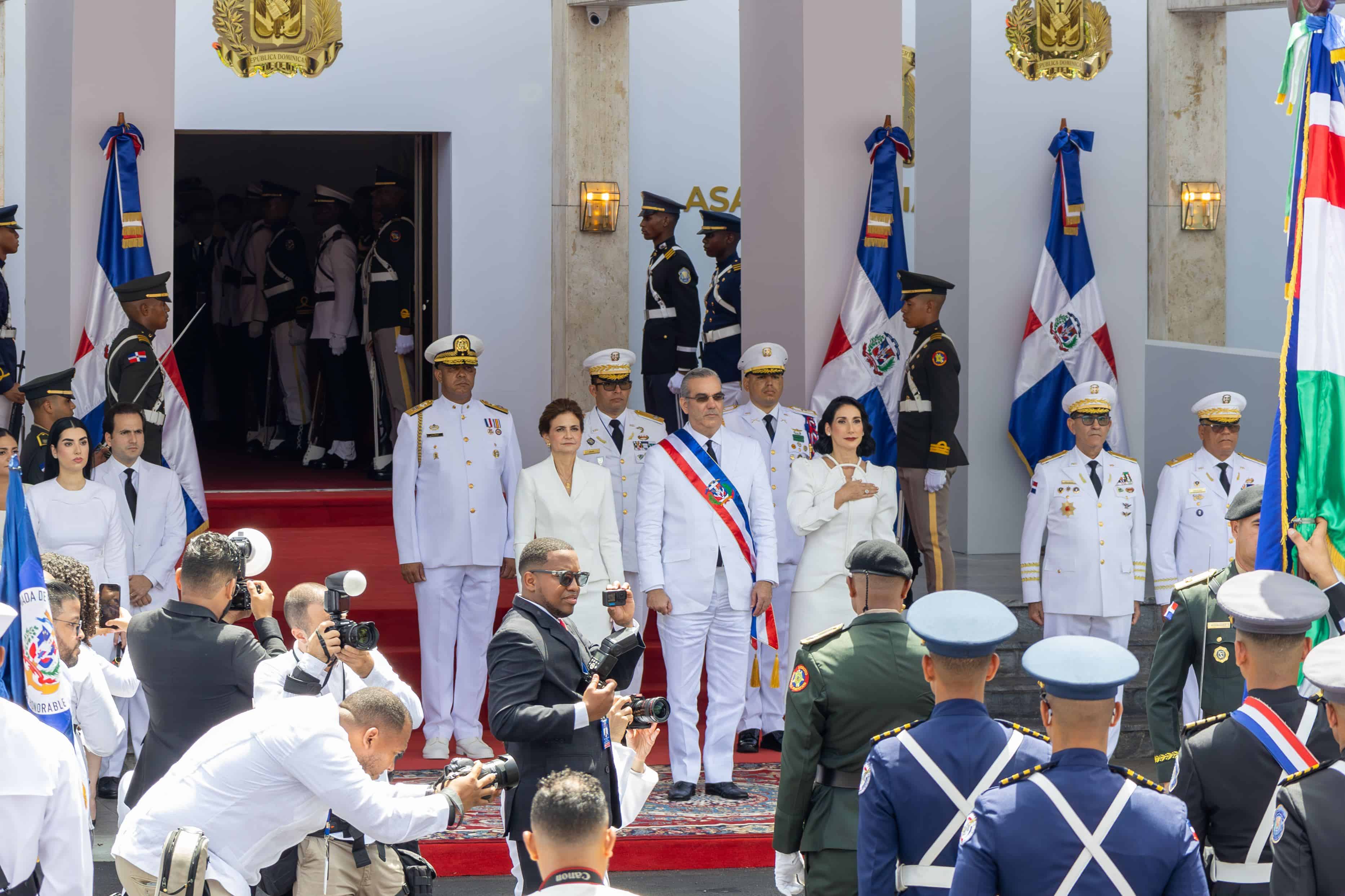 Raquel Peña, vicepresidenta de la república y Raquel Arbaje, primera dama, flanquean al presidente Luis Abinader mientras se entonan las notas del Himno Nacional.