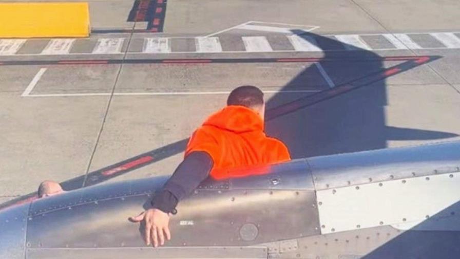 Un hombre abre la puerta de un avión y camina por el ala antes de ser arrestado en Melbourne