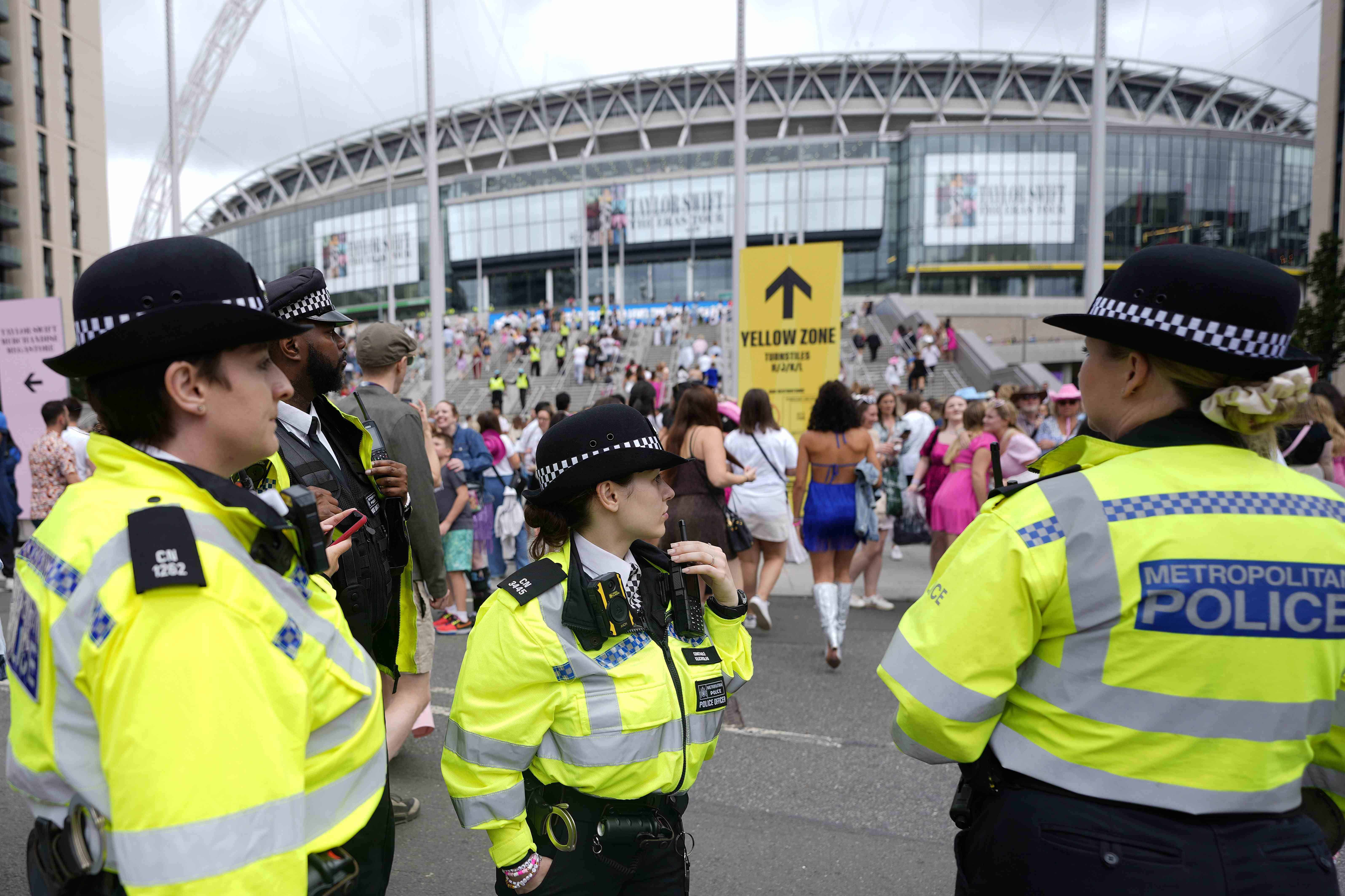 Agentes de policía observan la llegada de los fanáticos de Taylor Swift al estadio de Wembley en Londres, el jueves 15 de agosto de 2024, en el primer día de cinco conciertos de la gira Eras de Taylor Swift.