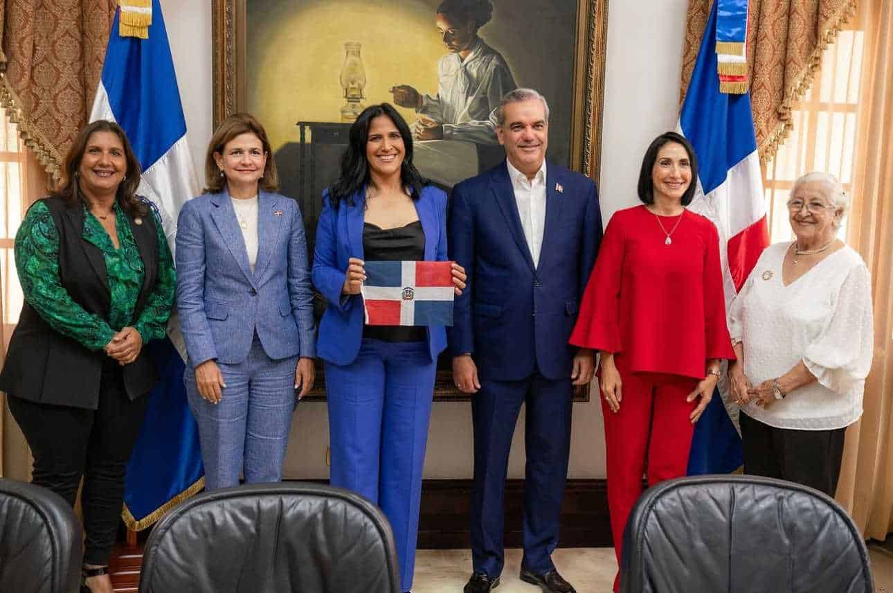 Thais Herrera, con la bandera dominicana, junto al presidente Luis Abinader.