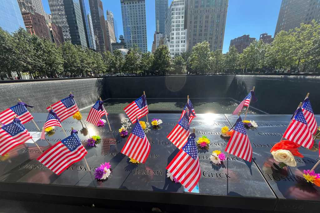 Se colocan banderas y flores junto a los nombres de los muertos durante los ataques del 11 de septiembre de 2001, en los estanques reflectantes del Museo y Memorial Nacional del 11 de Septiembre, el martes 10 de septiembre de 2024, en Nueva York.