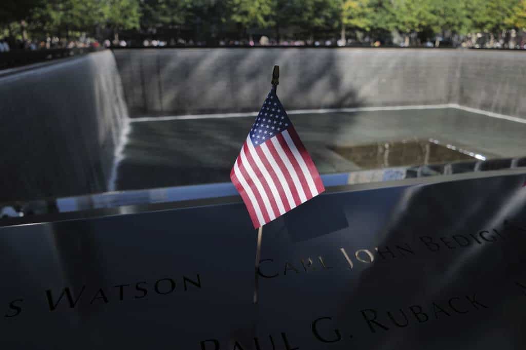 Se coloca una bandera junto a los nombres de los muertos durante los ataques del 11 de septiembre de 2001, en los estanques reflectantes del Museo y Memorial Nacional del 11 de Septiembre, el martes 10 de septiembre de 2024, en Nueva York.