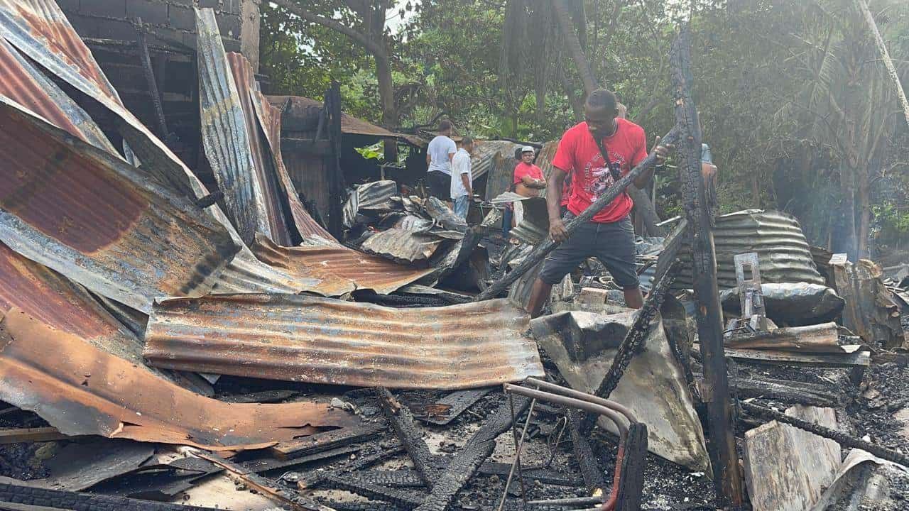 Un hombre remueve los escombros en el incendio que destruyó 18 casas en Santiago.