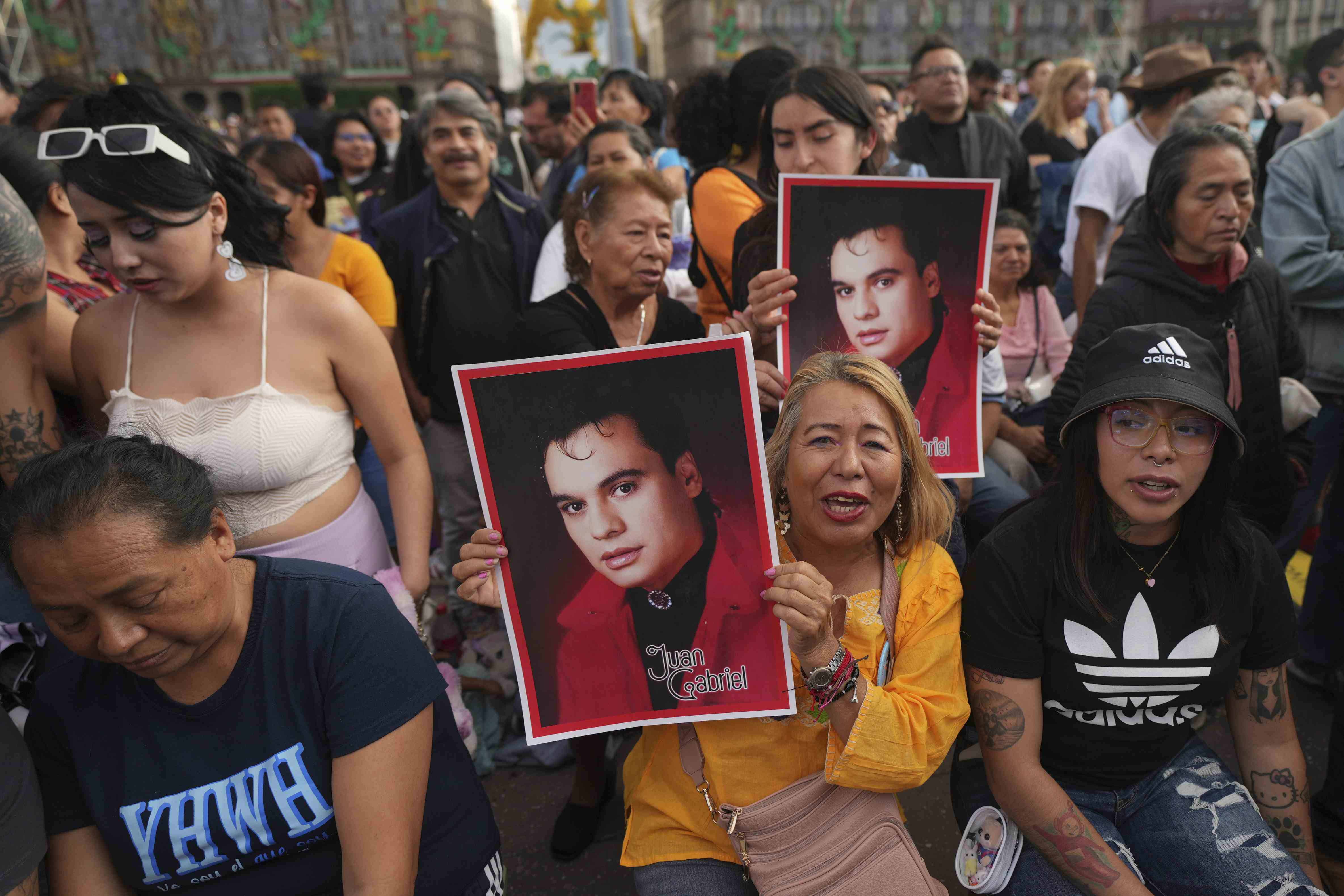 Fans de Juan Gabriel con afiches previo a una proyección de uno de sus conciertos en el Zócalo, la plaza principal de la Ciudad de México, el domingo 22 de septiembre de 2024.