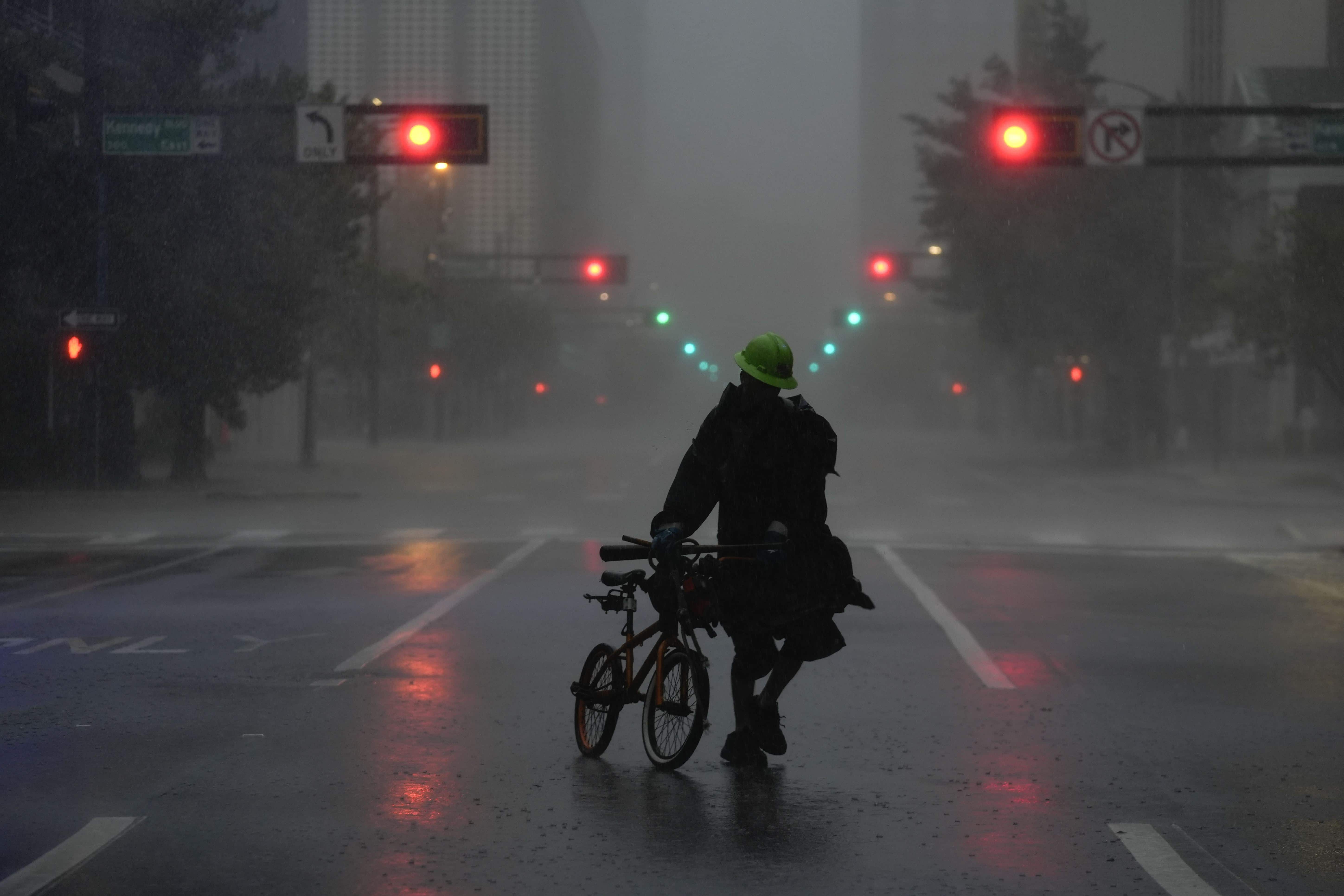Ron Rook, quien dijo que estaba buscando personas que necesitaran ayuda o escombros para limpiar, camina en condiciones de viento y lluvia en una calle desierta en el centro de Tampa, Florida, durante la aproximación del huracán Milton, el miércoles 9 de octubre de 2024.