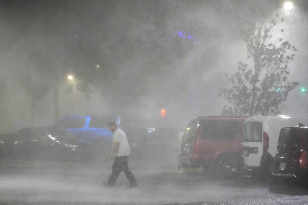 Max Watts, de Buford, Georgia, camina por un estacionamiento para revisar un tráiler estacionado en el exterior del hotel donde espera el paso del huracán Milton con otros compañeros, el 9 de octubre de 2024, en Tampa, Florida.
