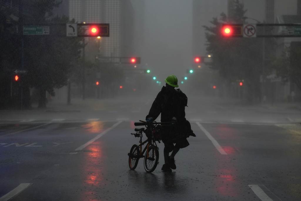 Ron Rook, que dijo que buscaba gente pudiese necesitar su ayuda o escombros que retirar, camina bajo la lluvia y el viento en el desierto centro de Tampa, antes de la llegada del huracán Milton a Florida, el 9 de octubre de 2024.