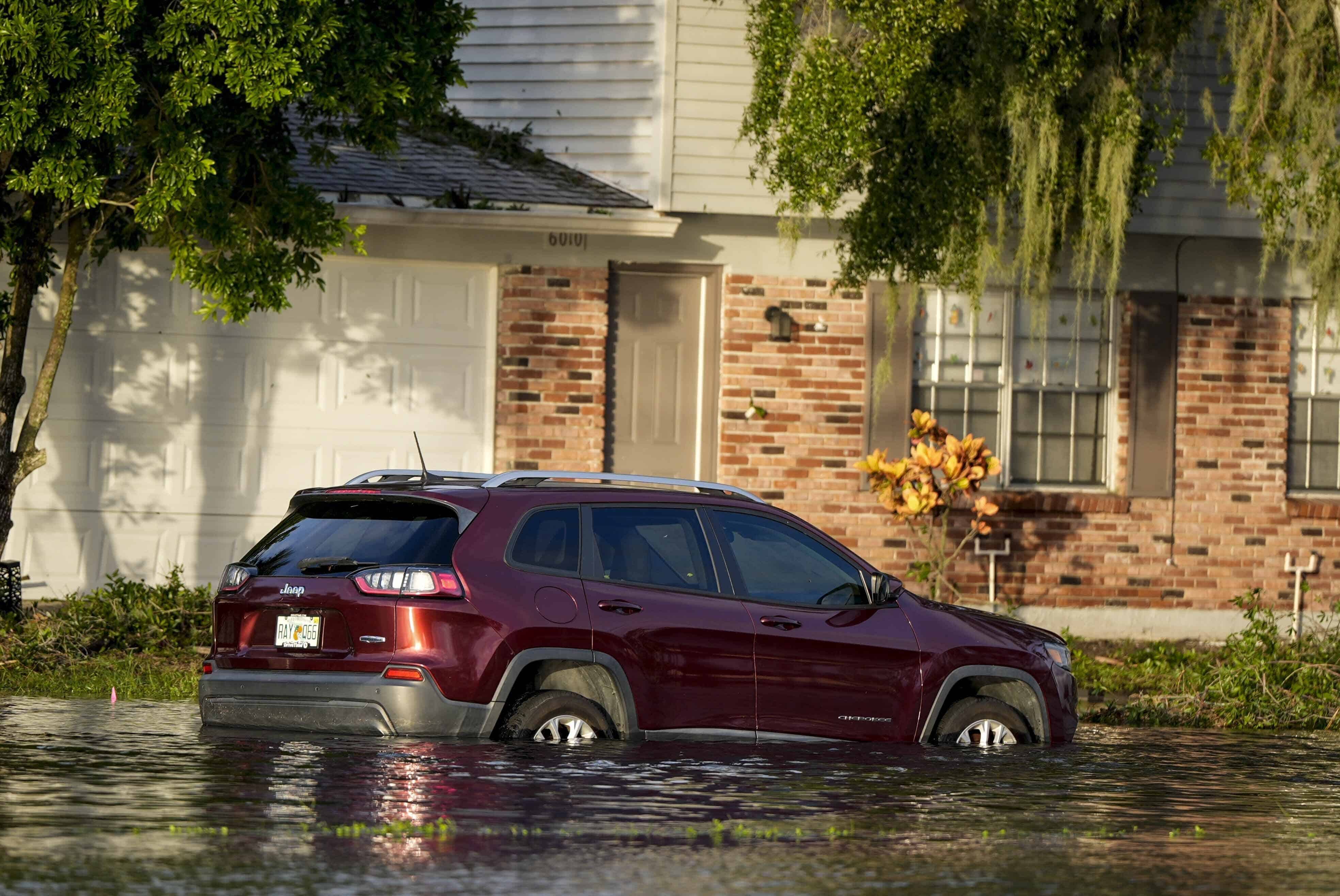 Un automóvil estacionado en el agua frente a una casa después del huracán Milton, el jueves 10 de octubre de 2024, en Tampa, Florida
