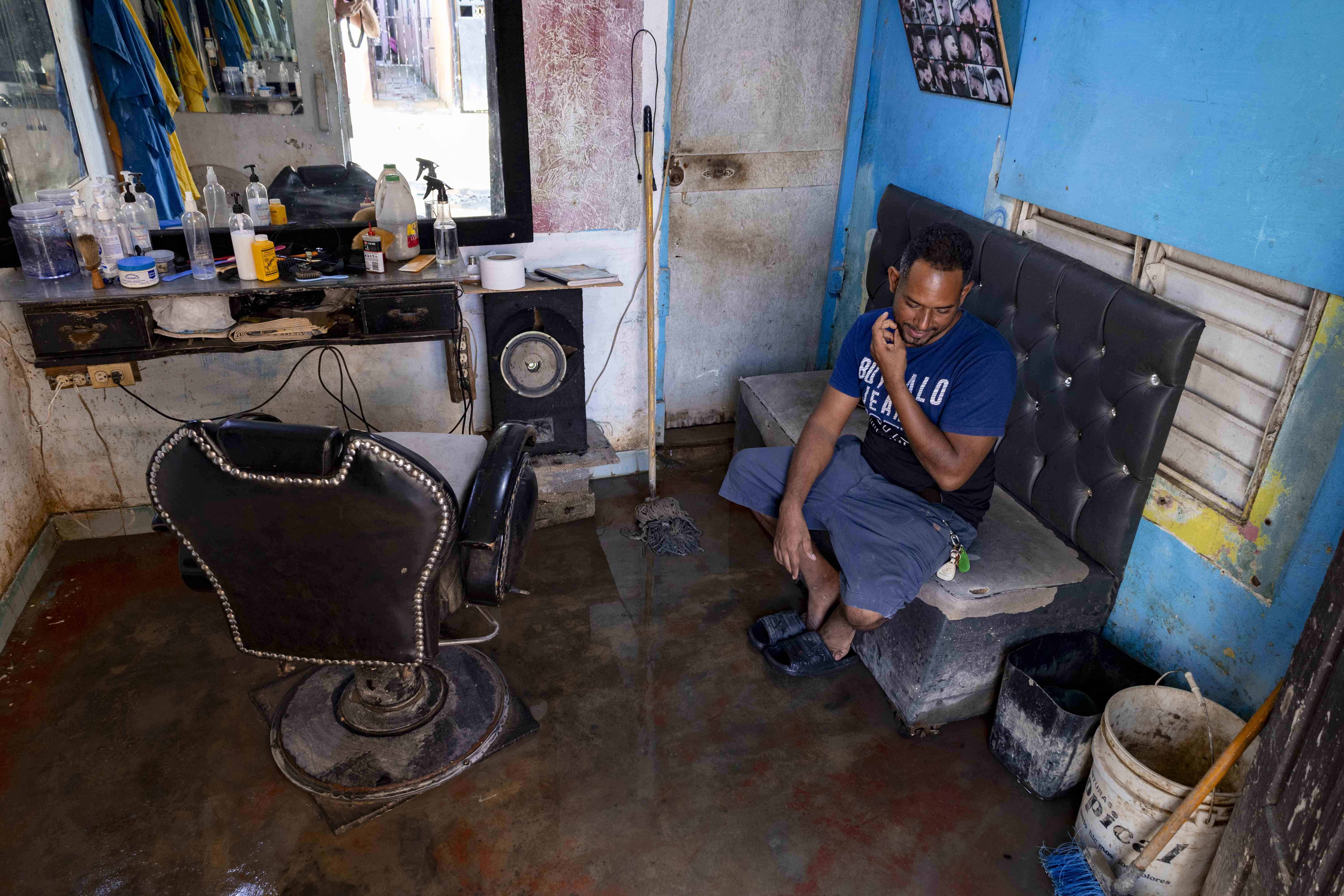 Omar Bienvenido sentado en la barbería. 