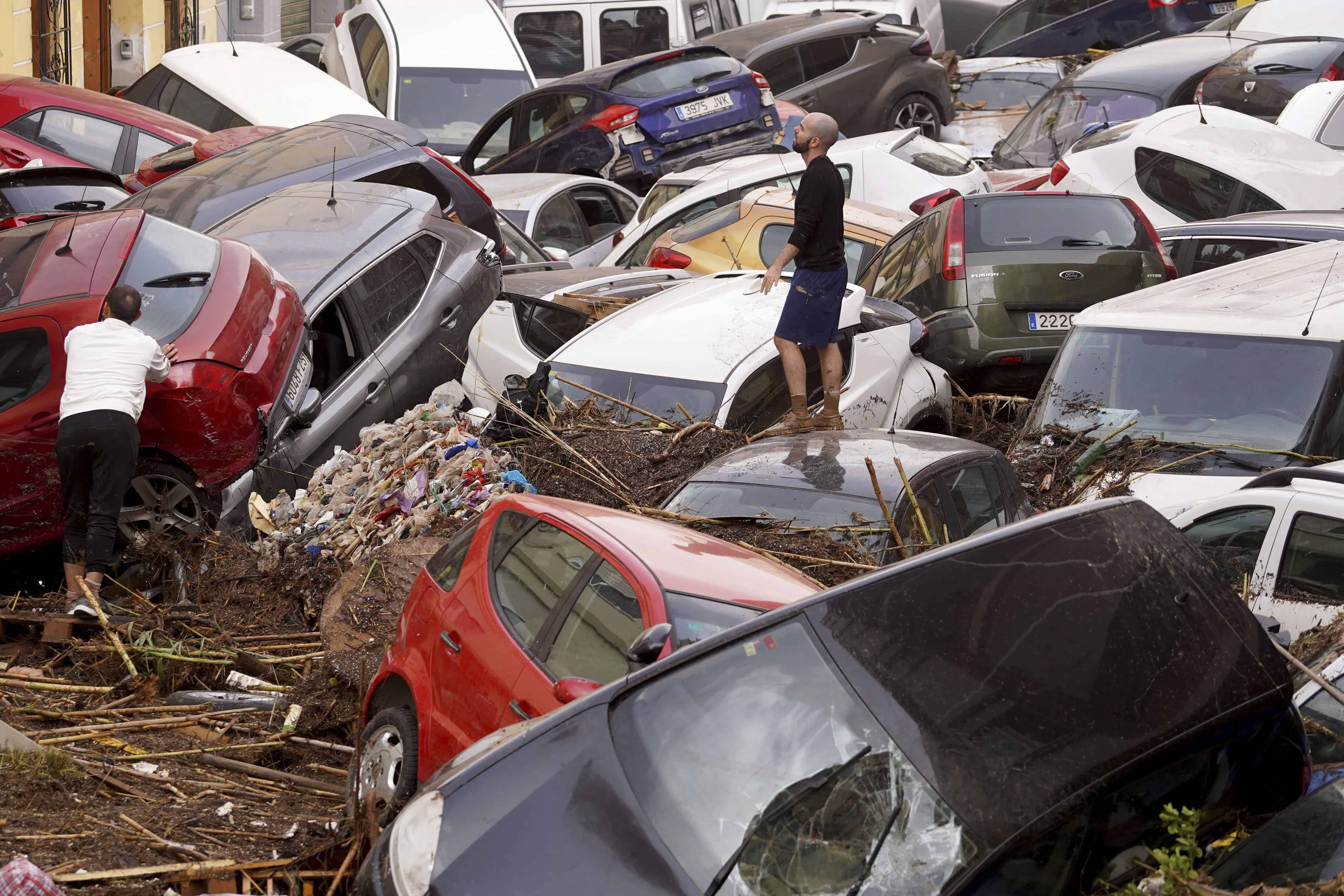 Los residentes observan los autos amontonados después de ser arrastrados por las inundaciones en Valencia, España, el miércoles 30 de octubre de 2024.