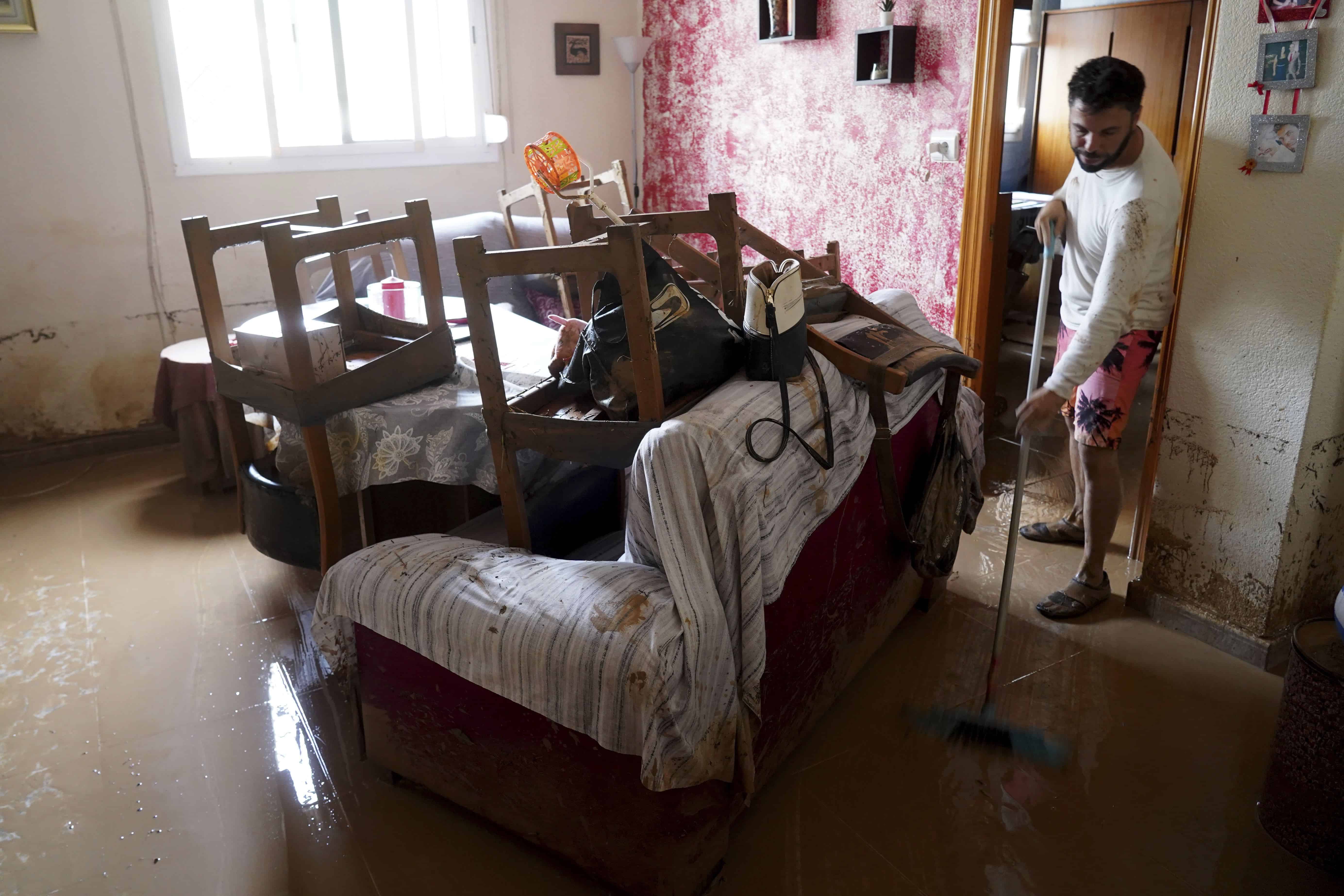 A man cleans his house affected by floods in Valencia, Spain, Wednesday, Oct. 30, 2024.