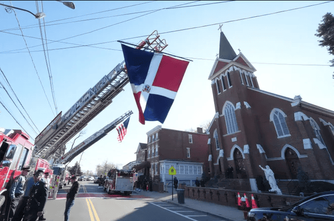 Las banderas de EE.UU. y República Dominicana a las afueras de la iglesia donde se llevó a cabo el funeral de Dariel Vásquez. 