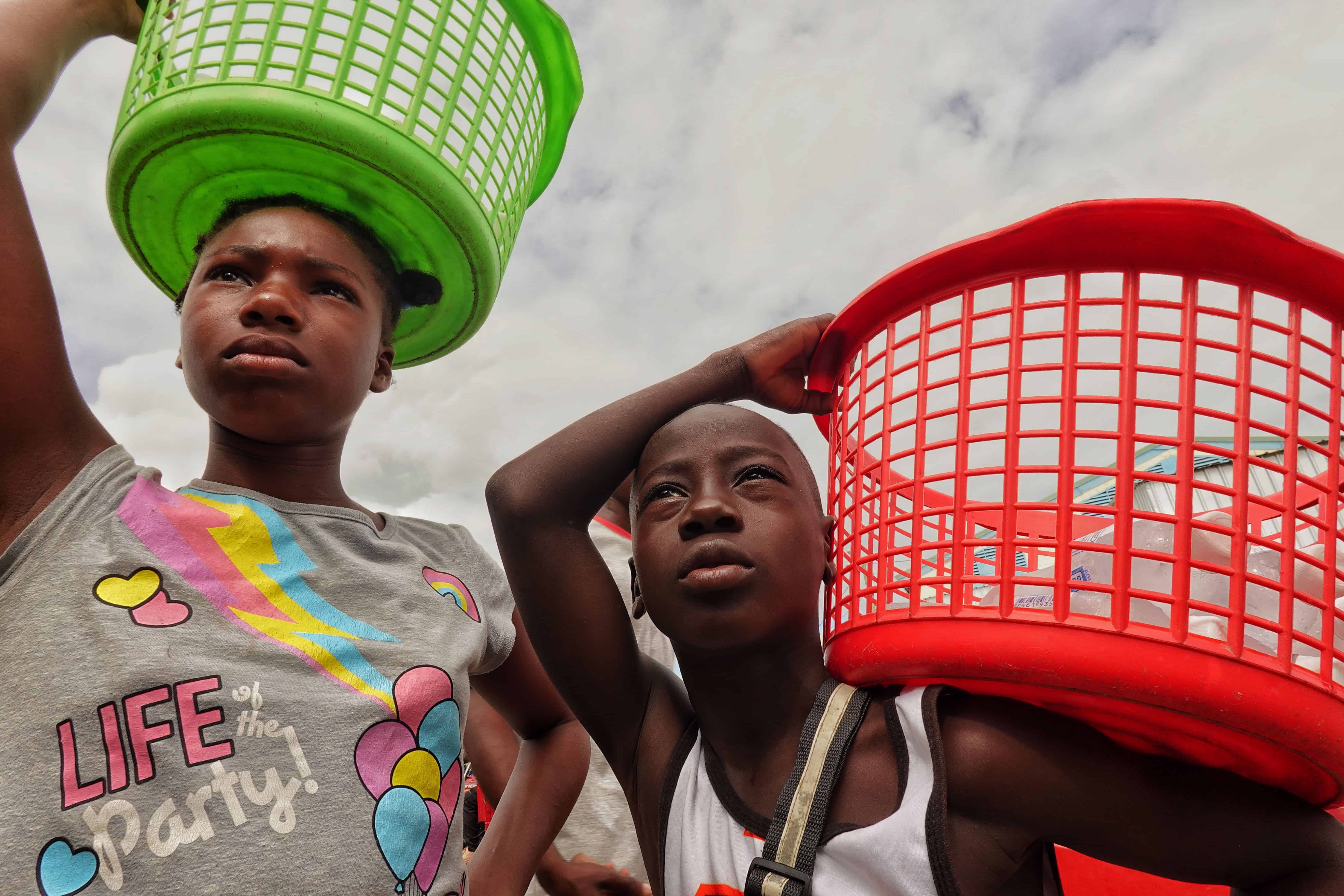 Dos niños haitianos venden agua fría en el mercado.