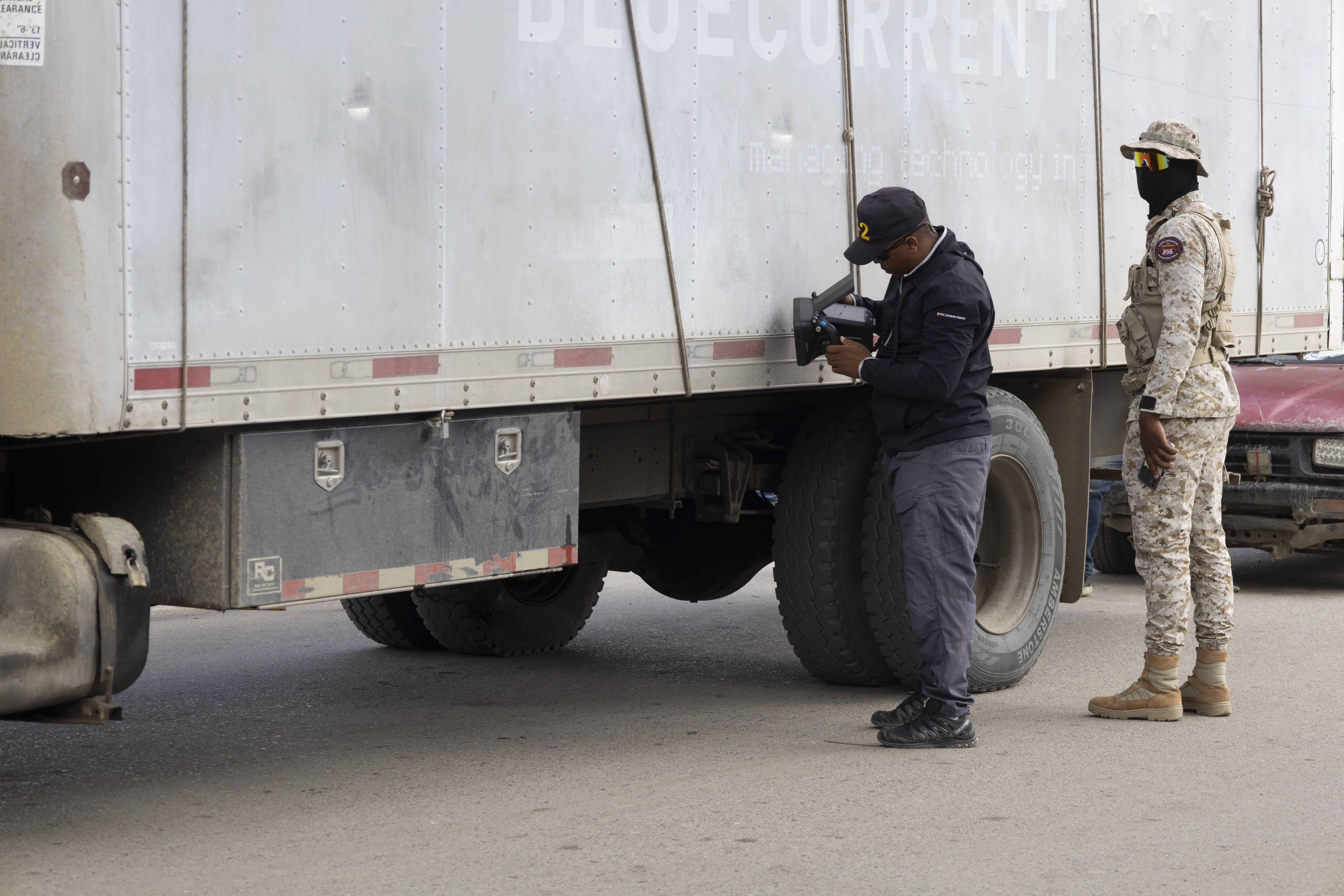 Militares dominicanos, con un escáner, controlan el interior de los cargamentos de los camiones. El militar dice que lo usan desde hace unos tres meses.