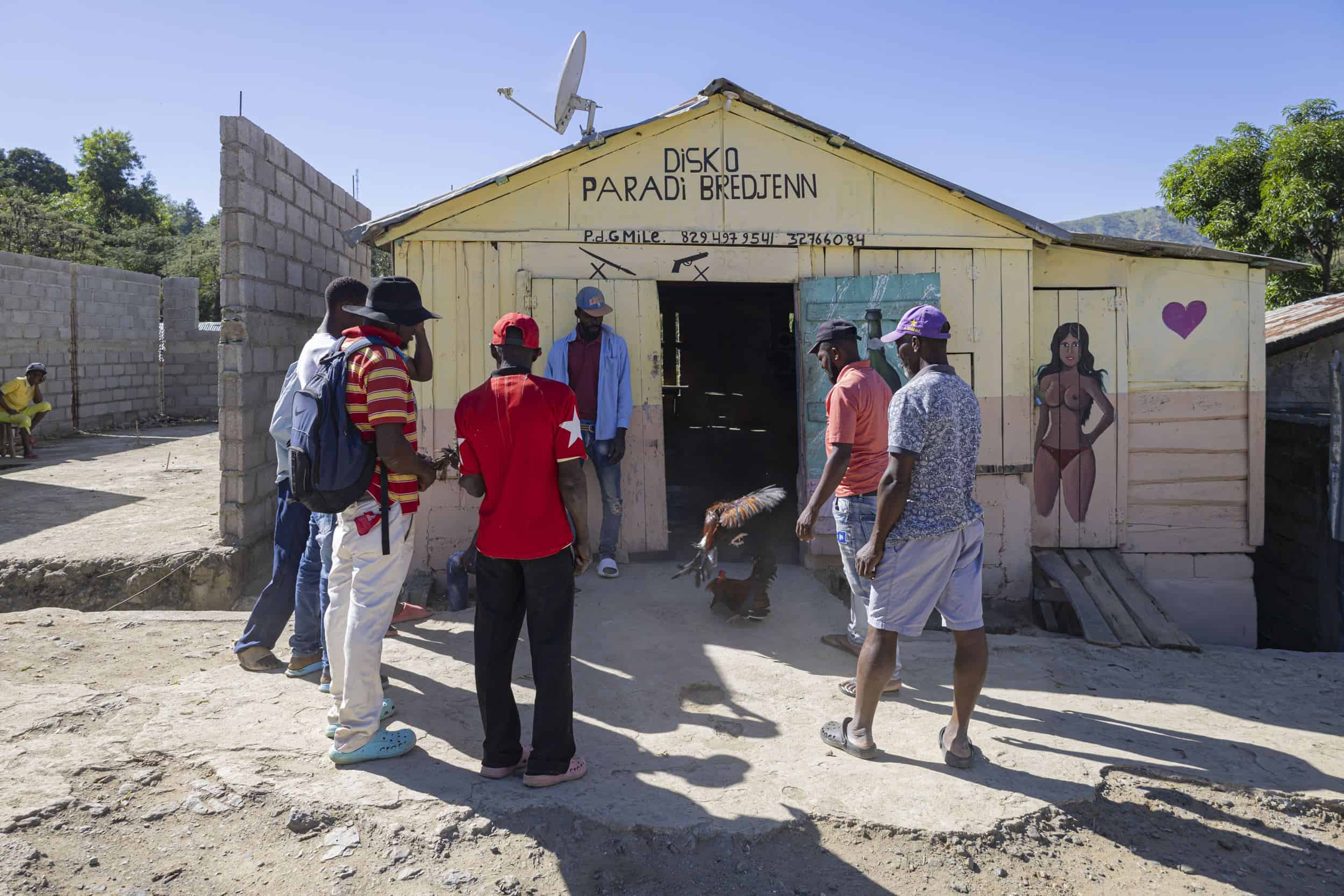 Hombres haitianos presencian una pelea de gallos.