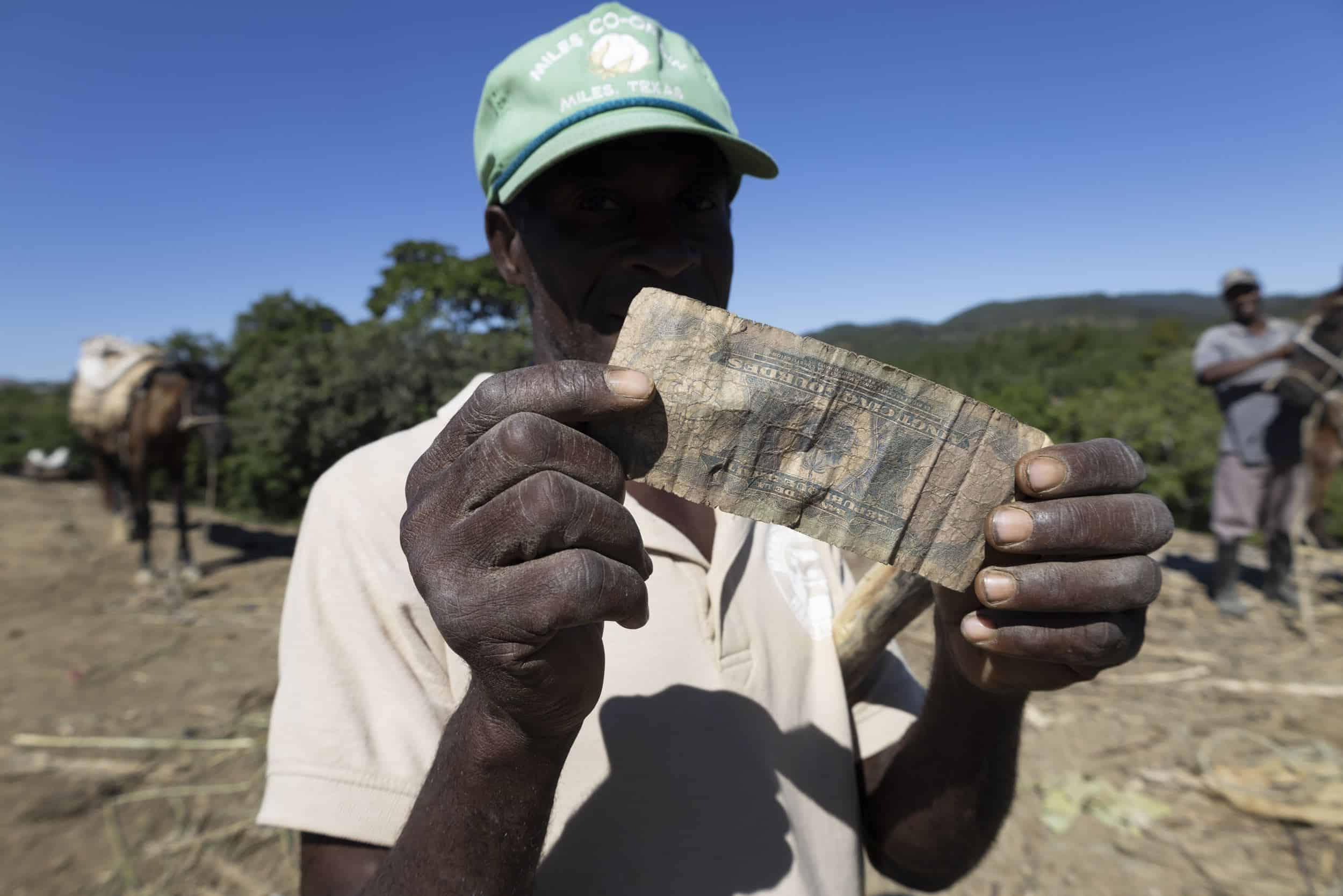 El cuidador de animales enseña un billete.