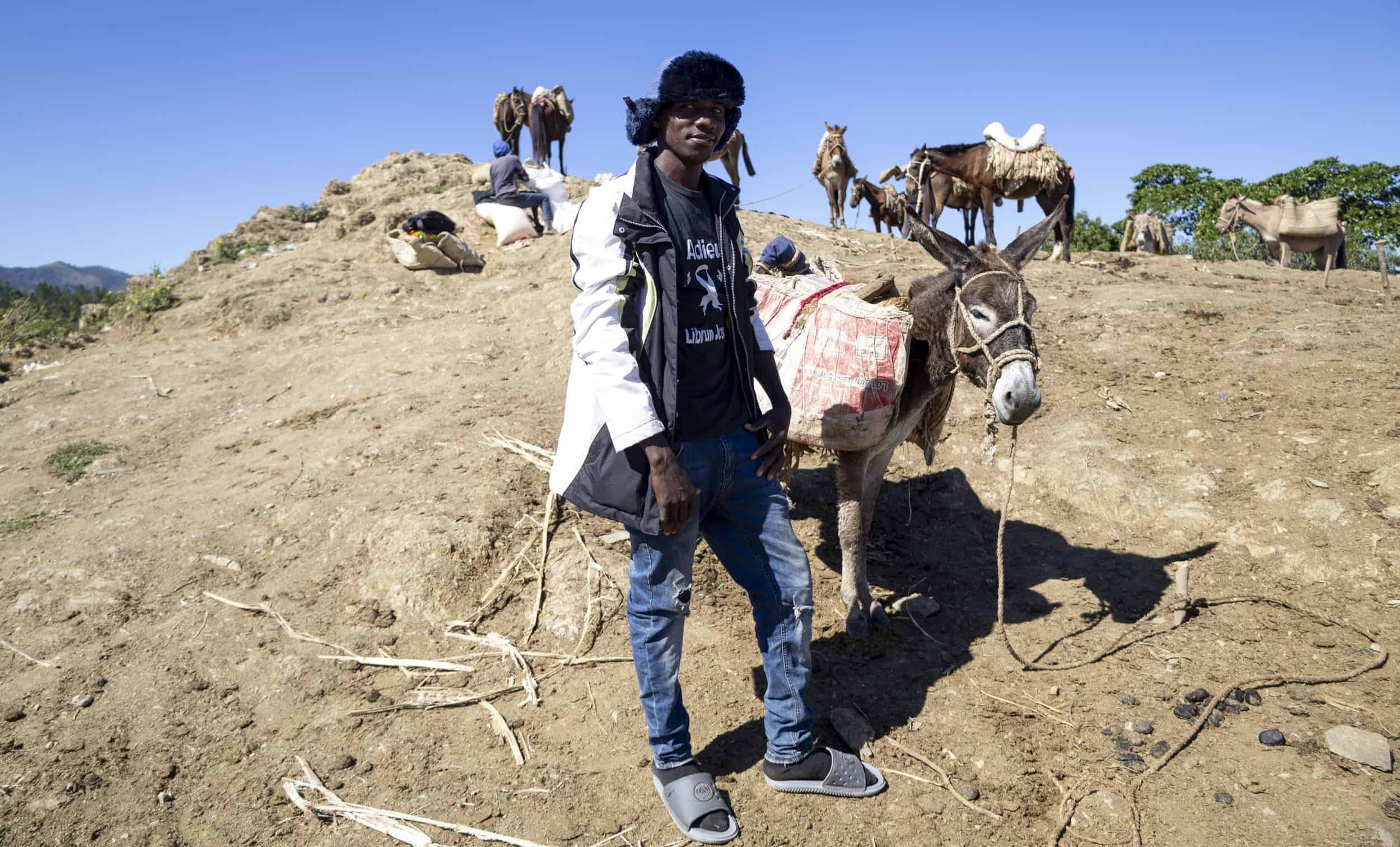 Un haitiano que habla bien español, al lado de un burro en Tilory.