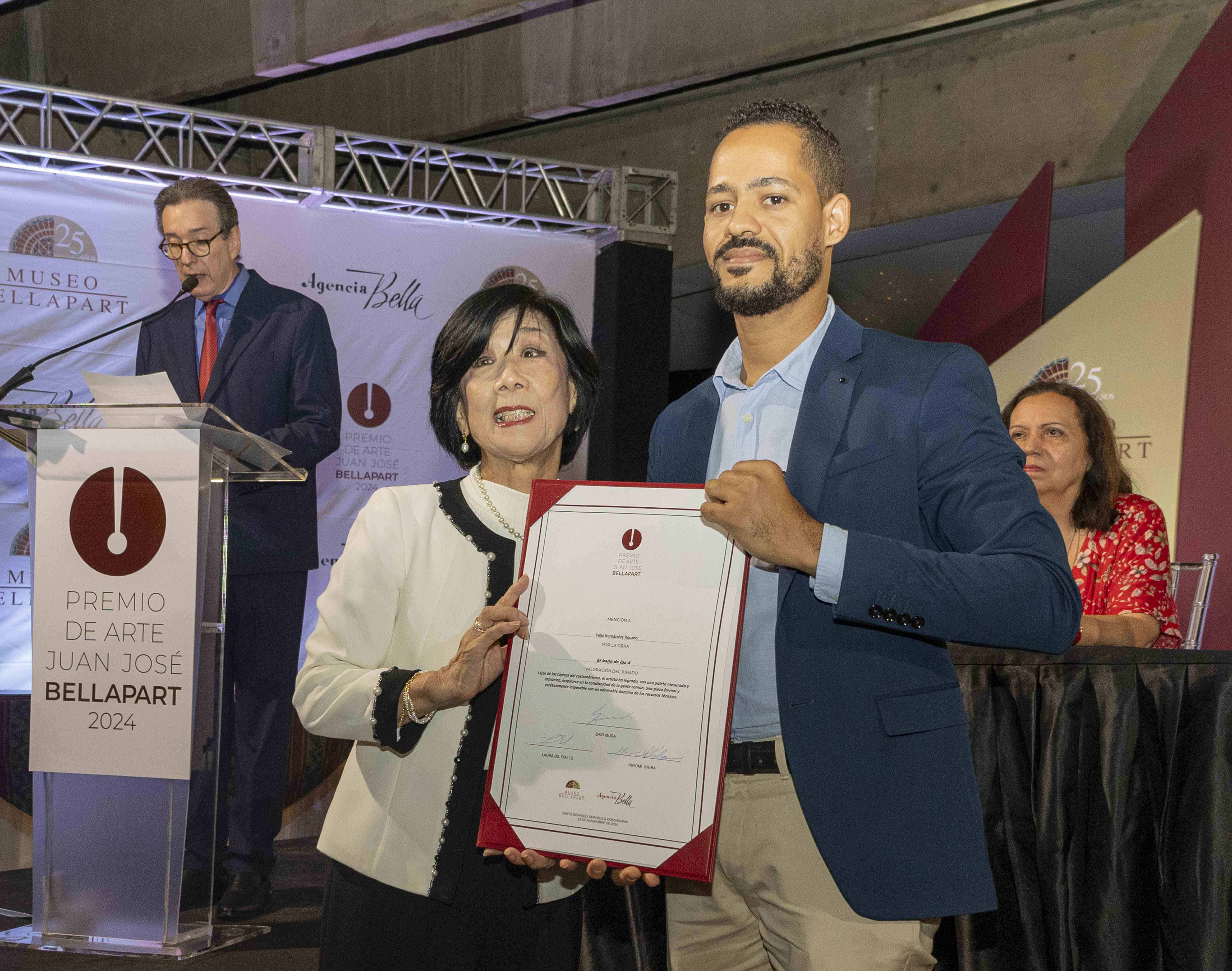 Félix Hernández Rosario recibe su certificado mención de honor por la obra "El baño de las 4" 