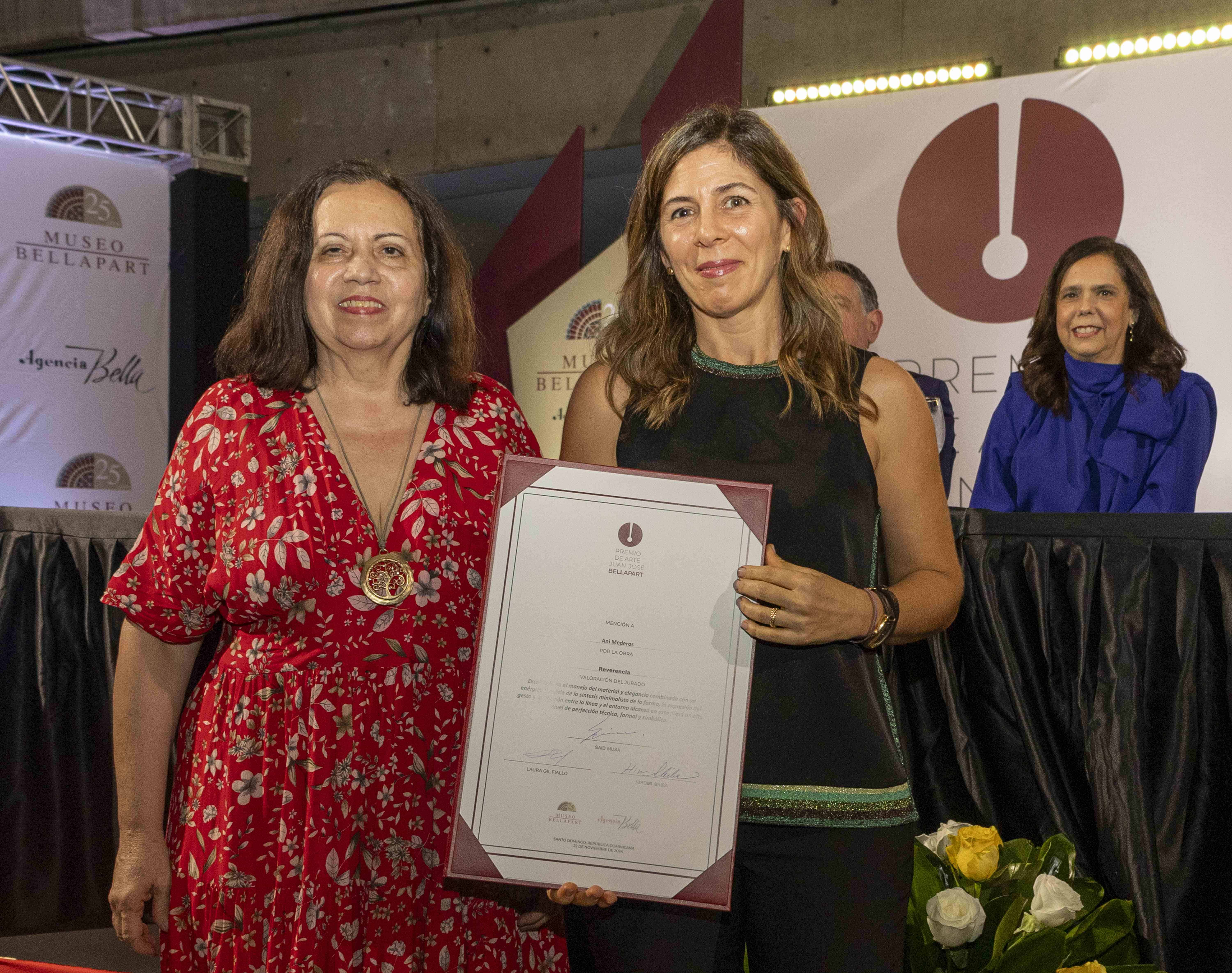 Ani Mederos recibe su certificado de mención de honor por su obra Reverencia.